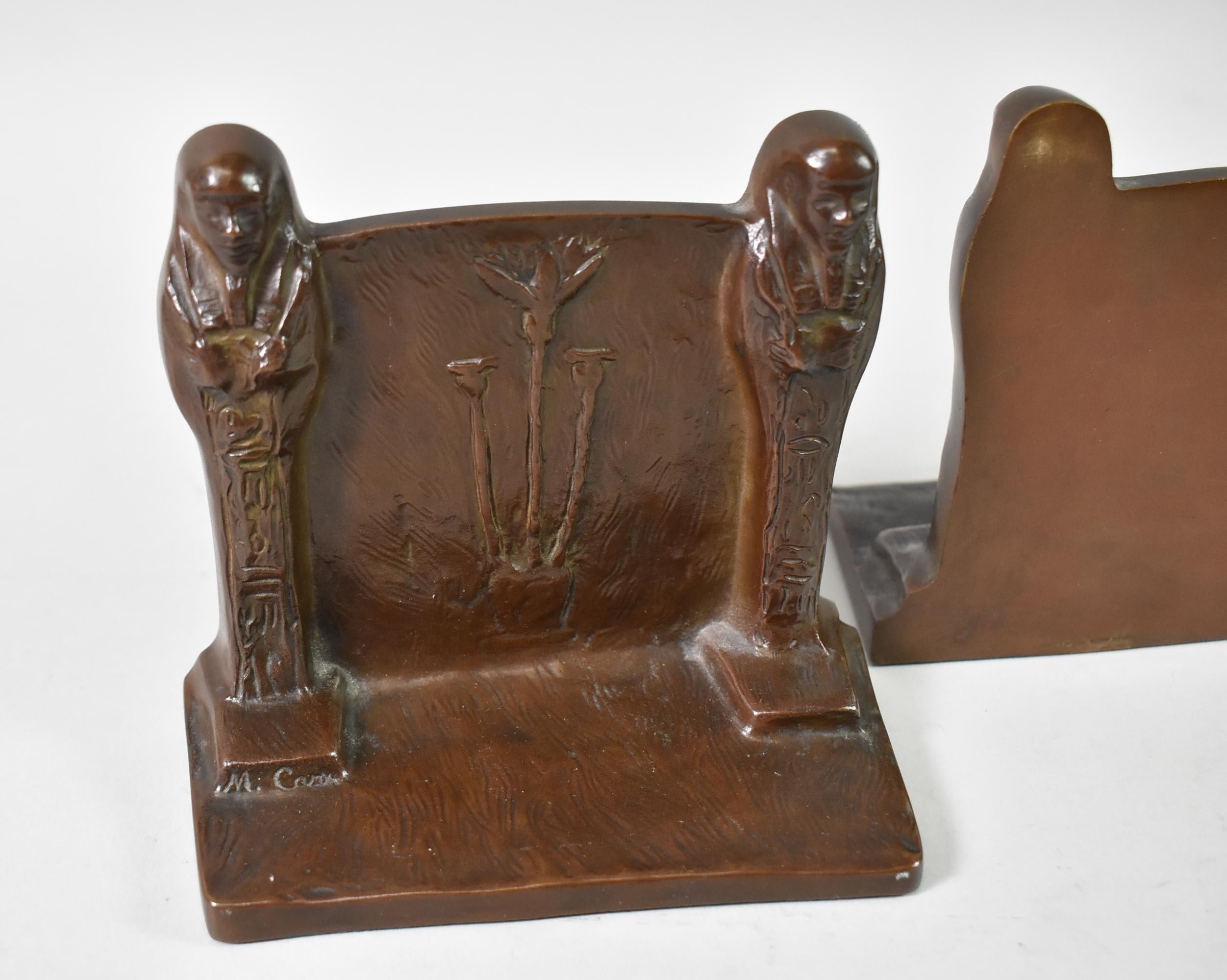 Pair of heavy bronze bookends in the Egyptian Revival style by Gorham Foundry, circa 1920's. Bookends feature two sarcophagi supporting a panel decorated with a potted plant design. Stamped M. Carr on the lower left sarcophagus base and stamped