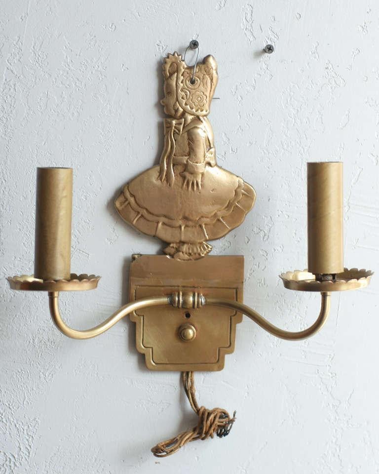 Pair of vintage circa 1947 solid bronze electric candelabra wall sconces featuring a young girl in bonnet used in the 1947 film Miracle on 34th Street.
 