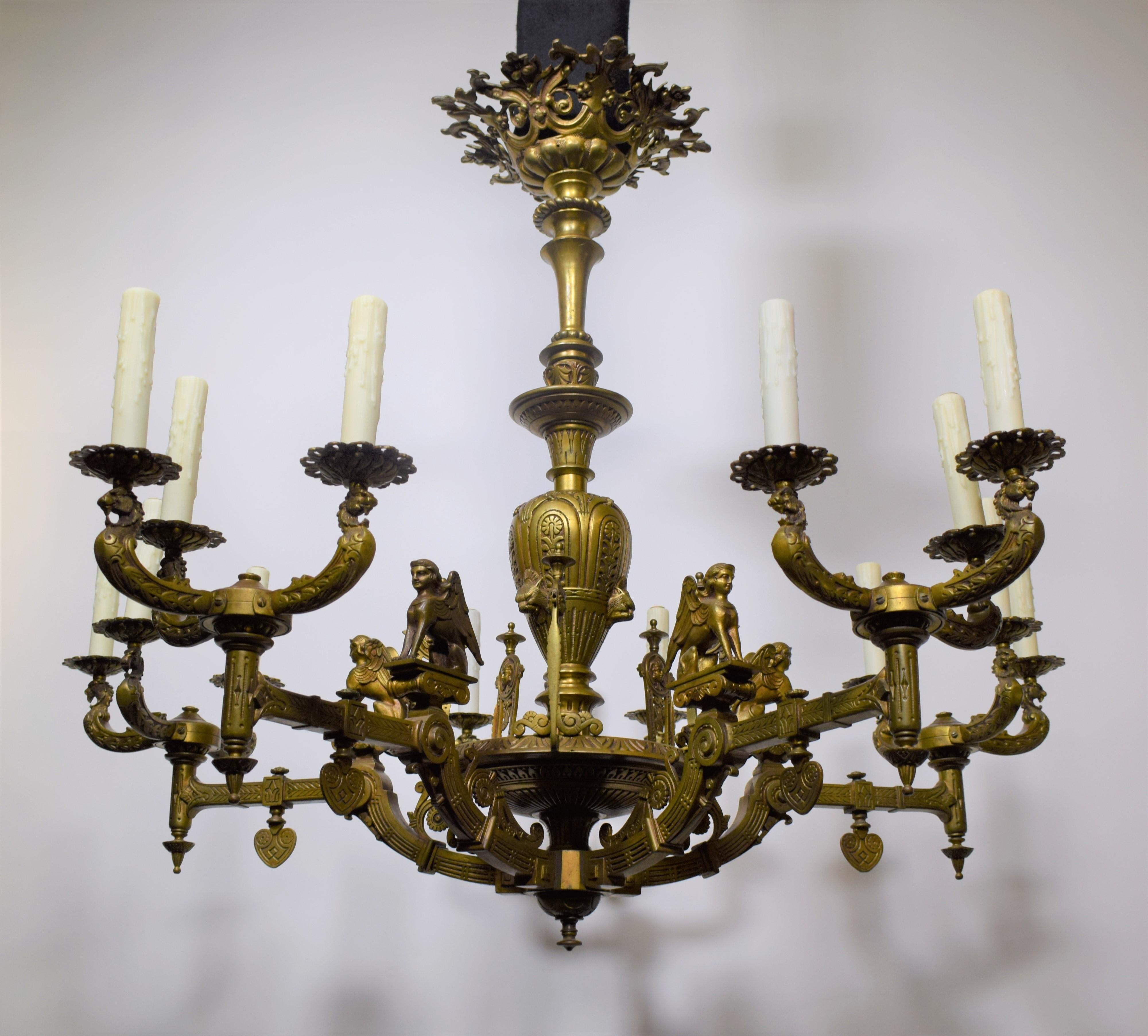 An Important and Unusual Empire style Chandelier featuring winged Caryatides, masks and stylized gas keys.
18 lights. Circa 1880. Measures: Height 38