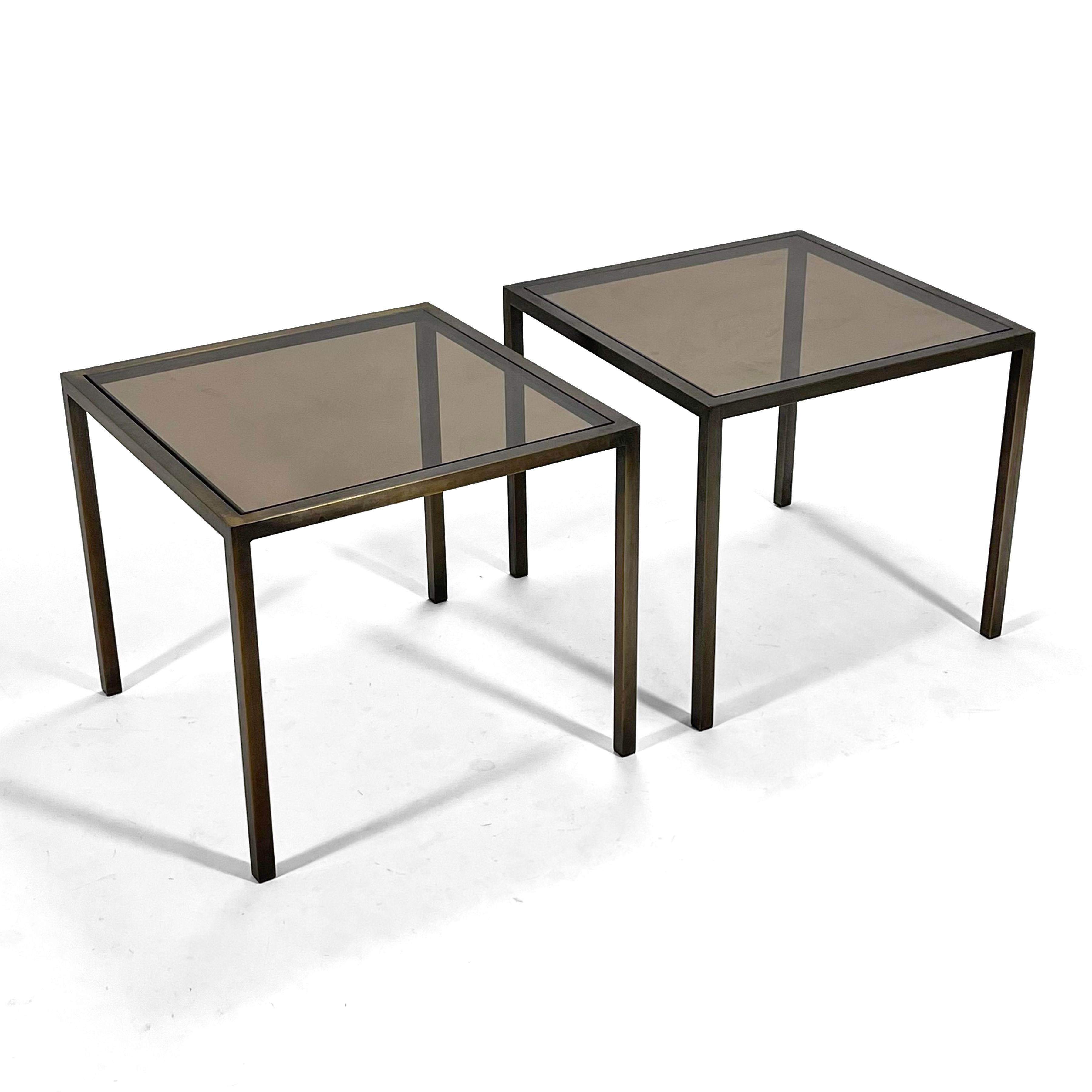 These striking end tables have a beautiful, subtle, minimalist design with bronze plated frames and inset bronze glass tops. The design has similarities to Florence Knoll's work. Possibly custom fabricated, they came from the corporate offices of