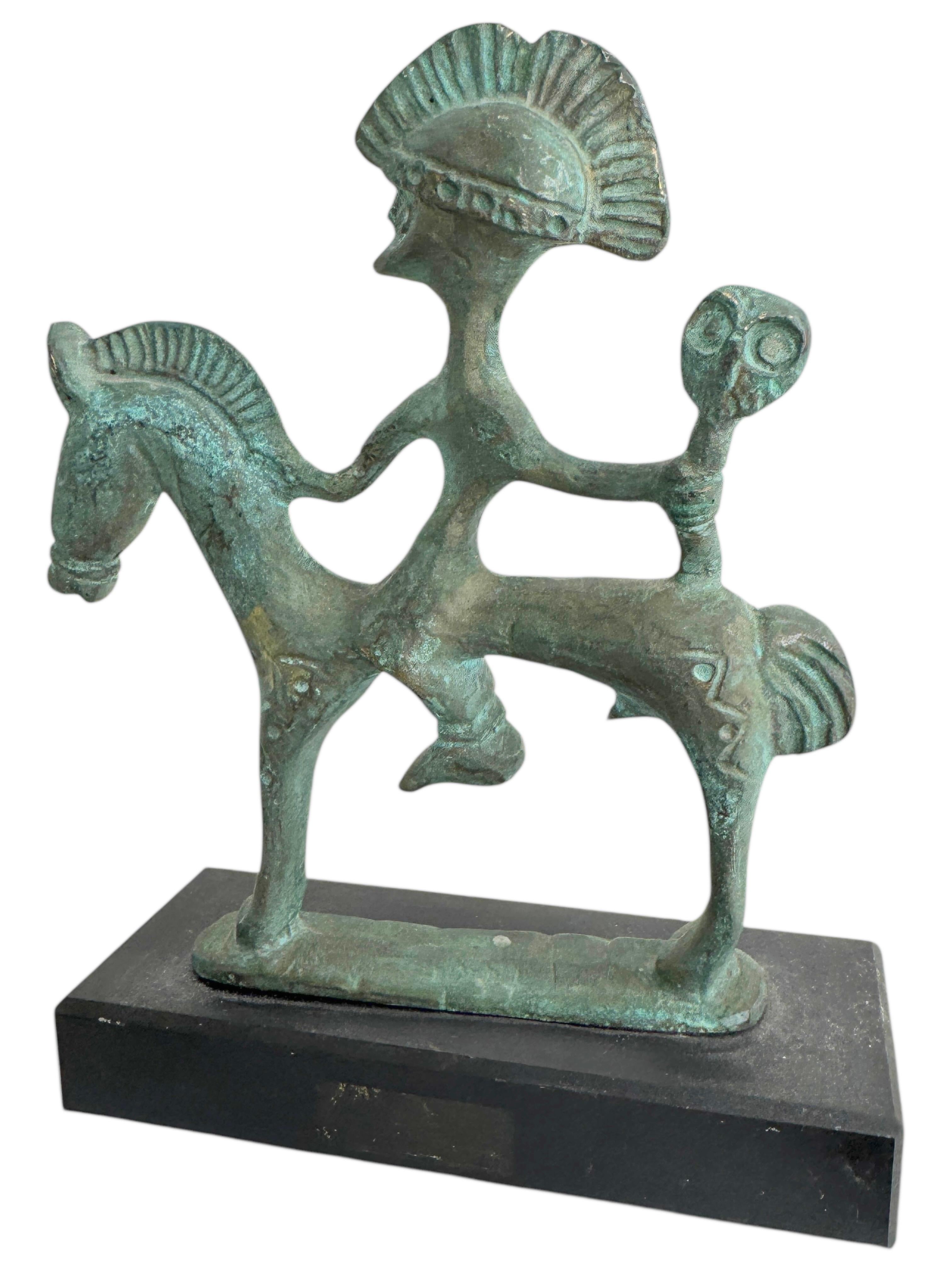 Questa scultura in bronzo, nello stile delle antiche statue e figure degli Etruschi, è uno splendido oggetto d'arredo per interni. È un cavallo etrusco incredibilmente stilizzato con un cavaliere su una base di marmo e ha una finitura patinata.
