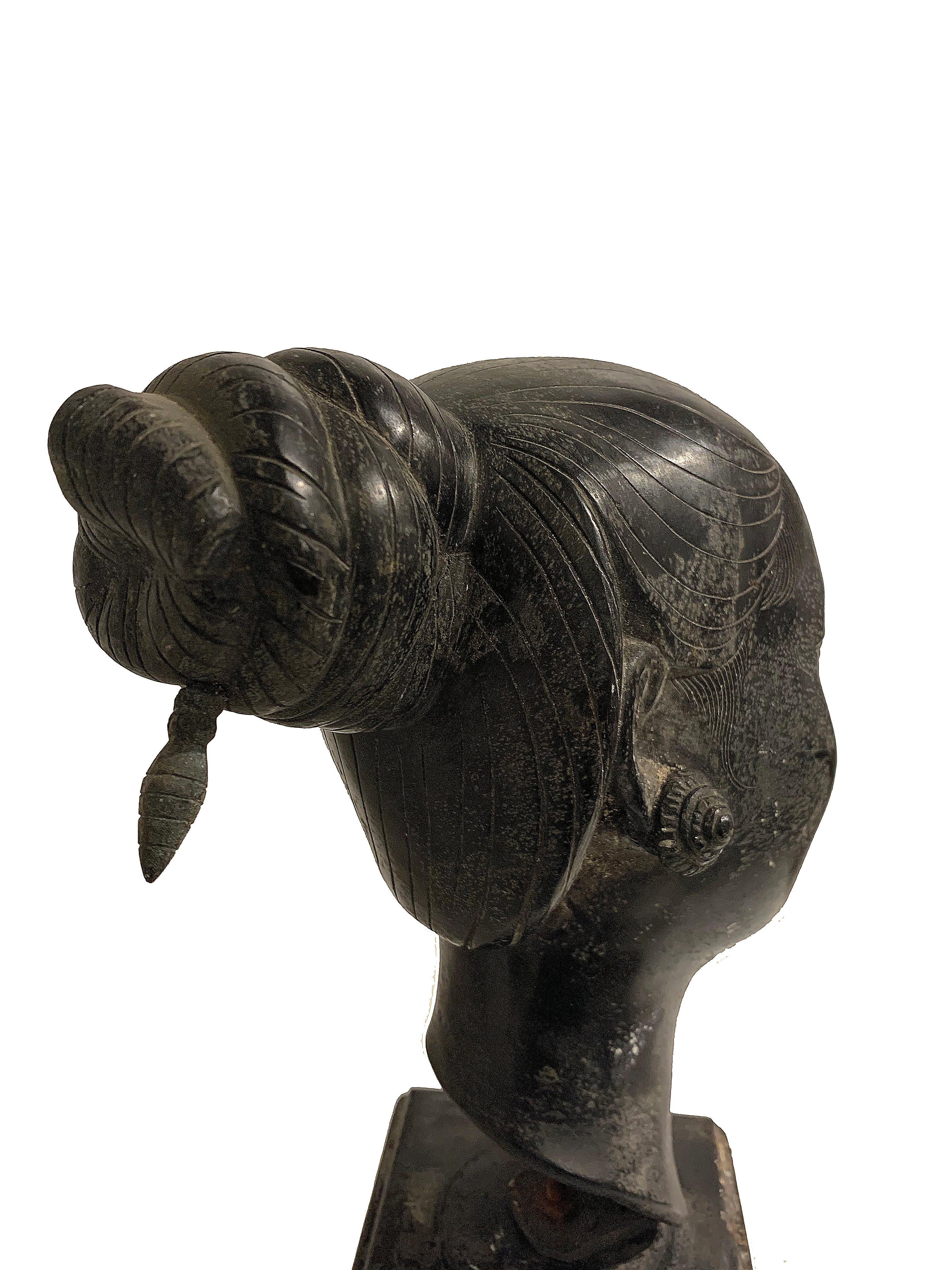 Escultura figurativa femenina de bronce. Se asienta sobre una base de madera, ambas con cierto desgaste y decoloración. Sin firmar, sin fecha.
