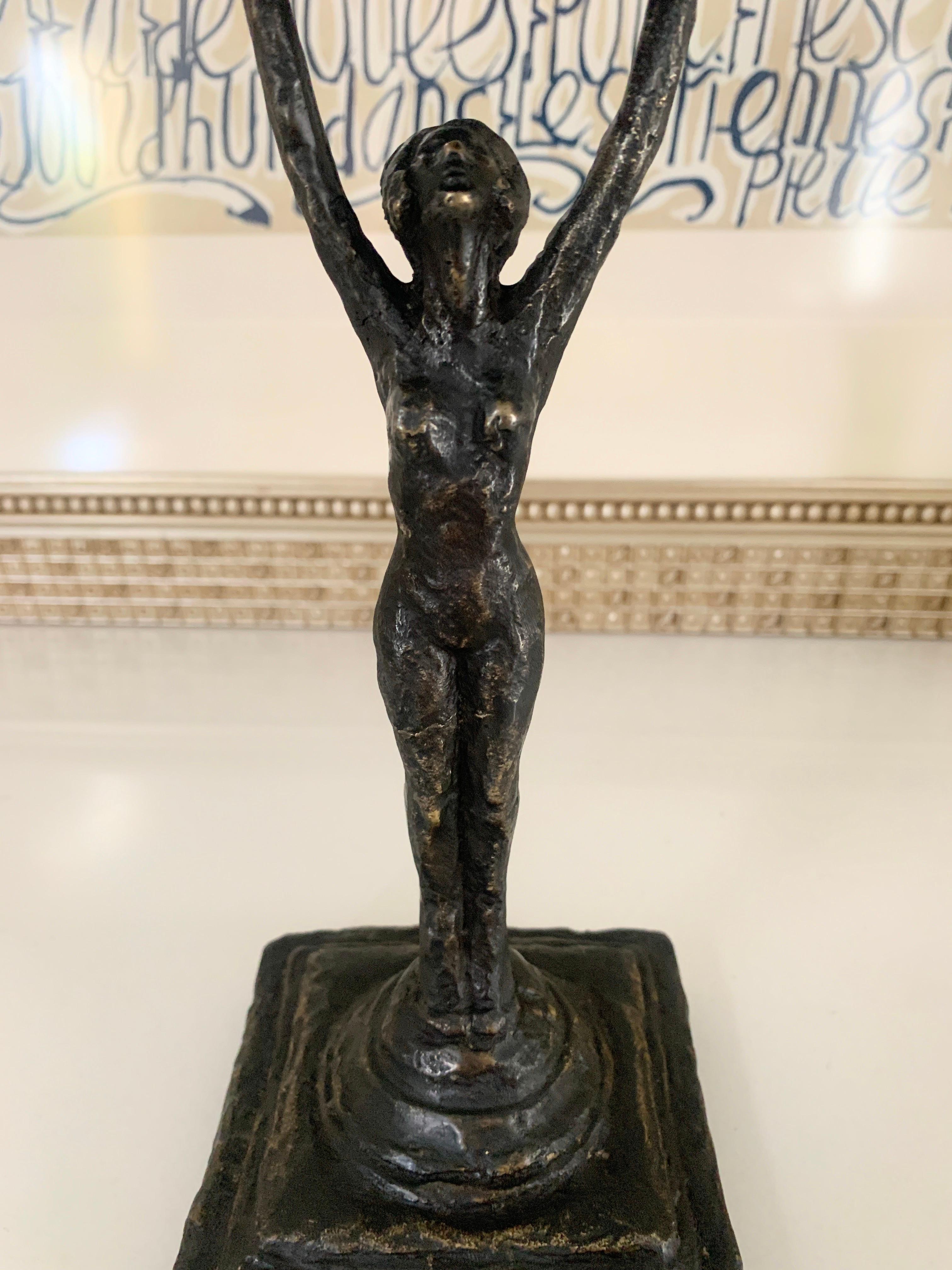 A wonderful carved bronze figure holding a cup above her head - a stand alone sculpture for any room. Be creative and use the piece on a desk or table holding anything from Appetizers to business cards. The piece has a deep patination and is of good