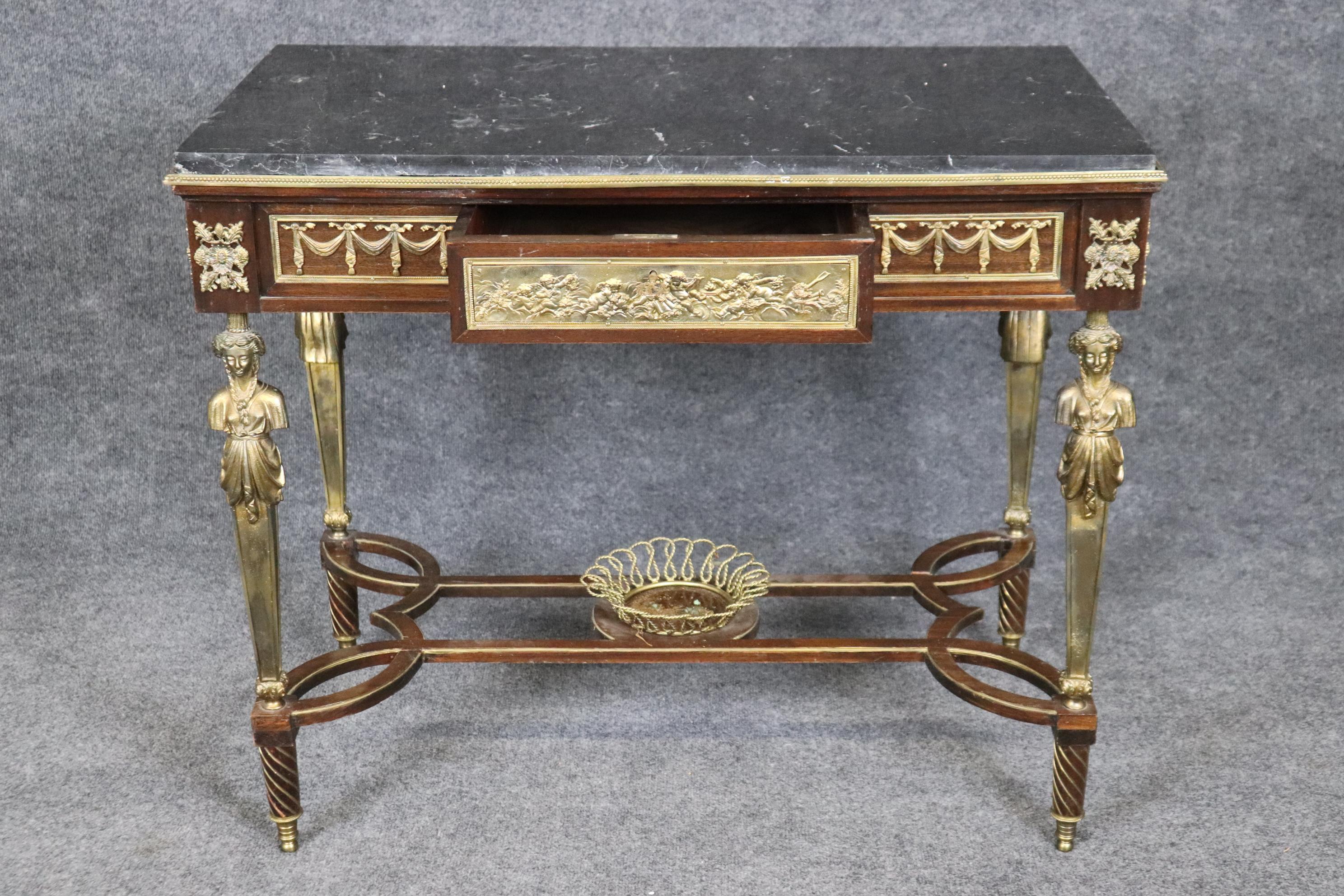 This is a superb desk or center table (that can be used as a desk) designed in the unmistakable manner of the legendary Adam Weisweiler (biography shown below) who used full body relif bronze figuresof maidens and Egyptian pharoahs and a basket