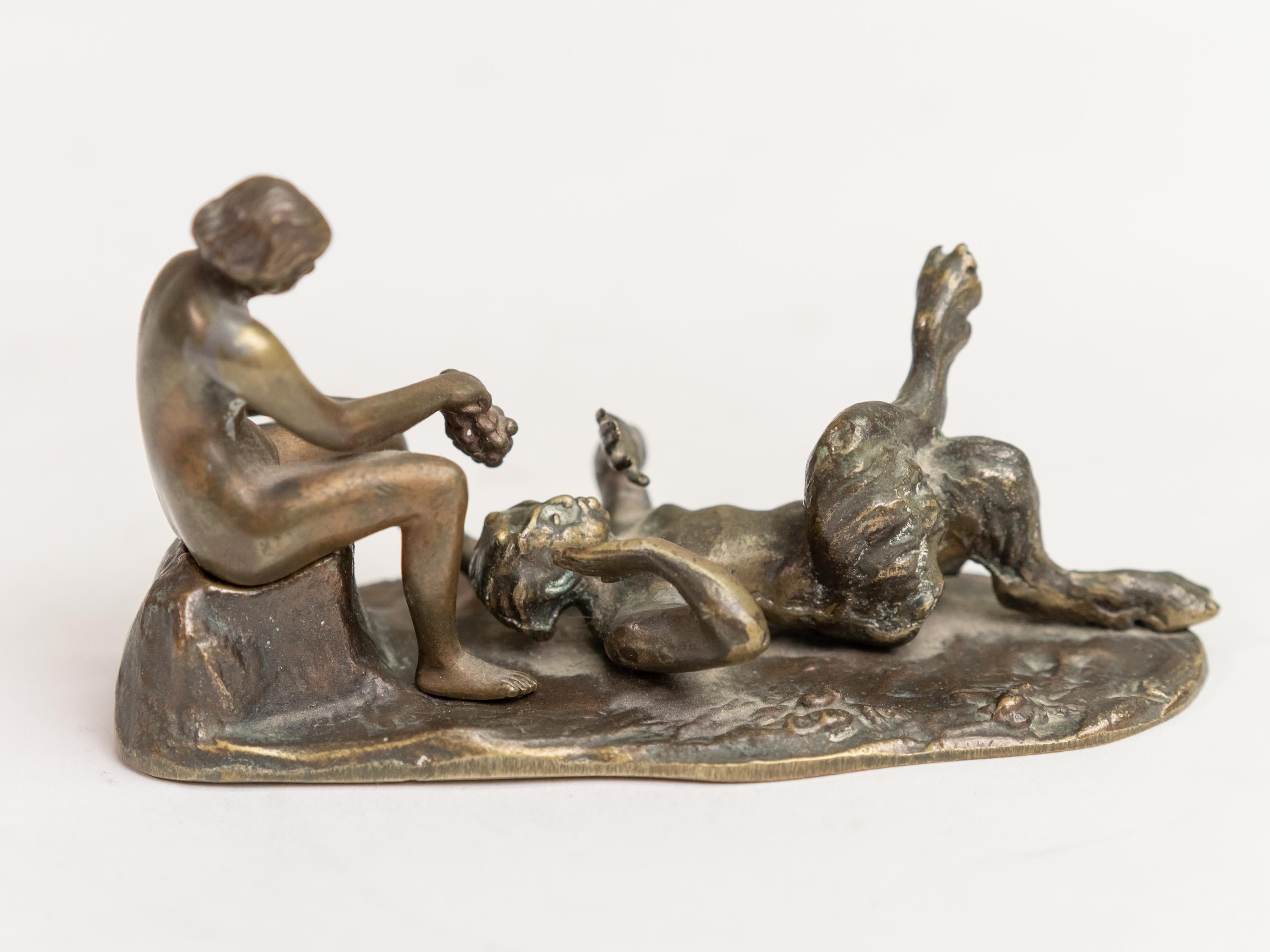 Bronze figural group erotic scene in the manner of Bergman depicting a bacchante hold a grape over a Faun.