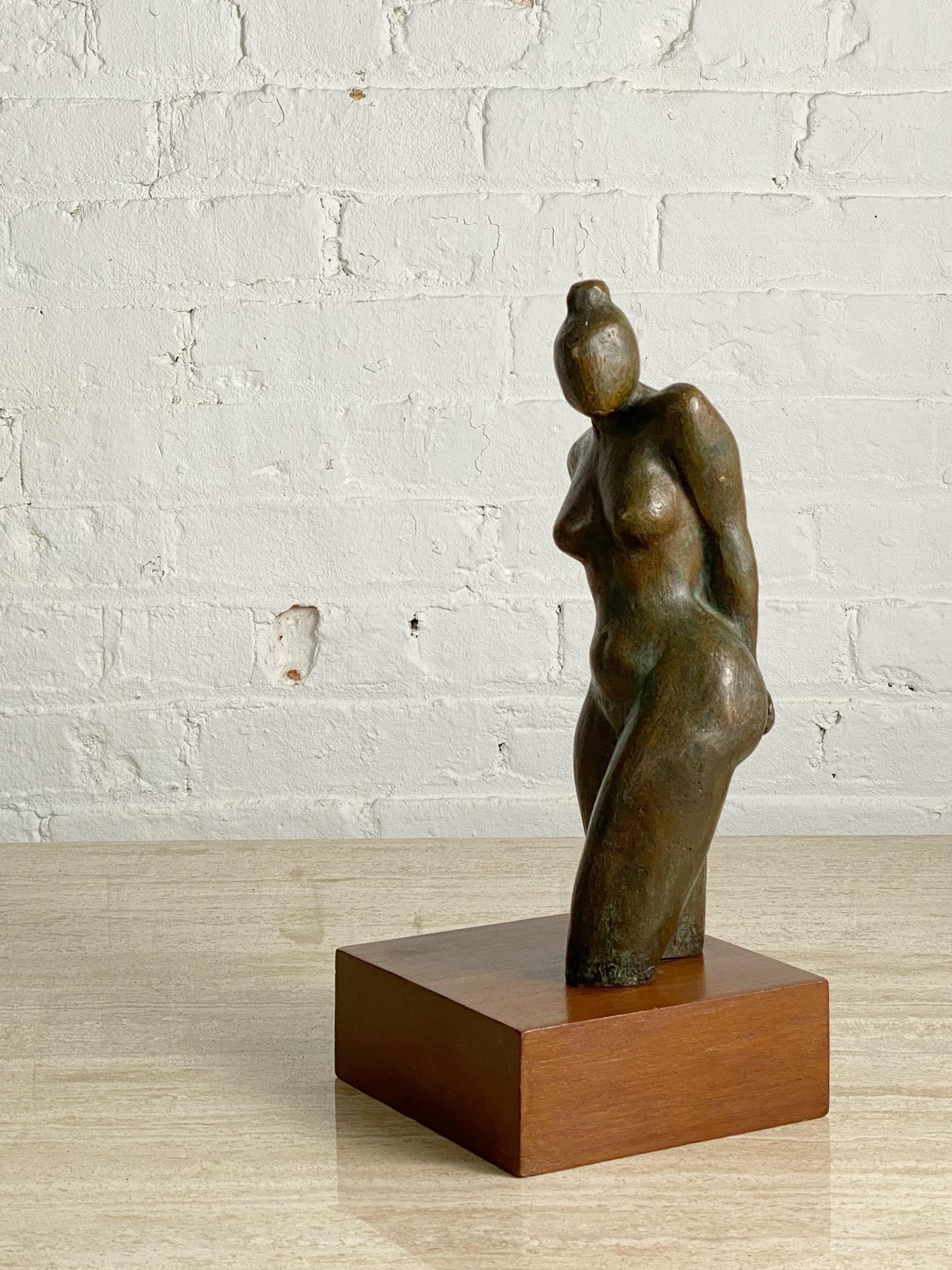 A cast bronze sculpture on wood base. Nude female form. Deep rich patina ranging from dark coppery tones to pale greens. Sign 