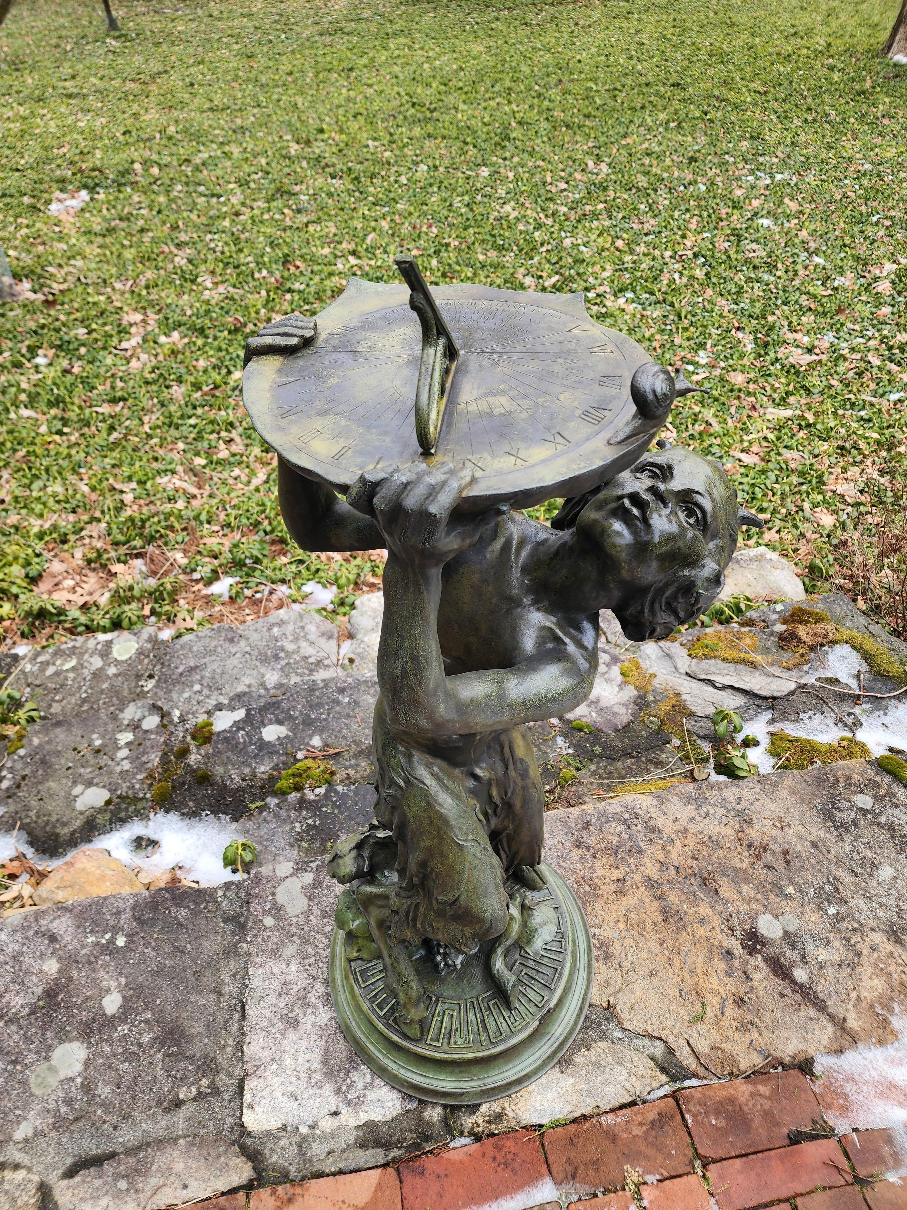 Reloj de sol figurado de bronce con figura de sátiro del escultor estadounidense Robert Ingersoll Aitken (1878-1949), el sátiro sostiene una gran concha estilizada mientras está agachado debajo de ella, la concha rematada con una placa de reloj de