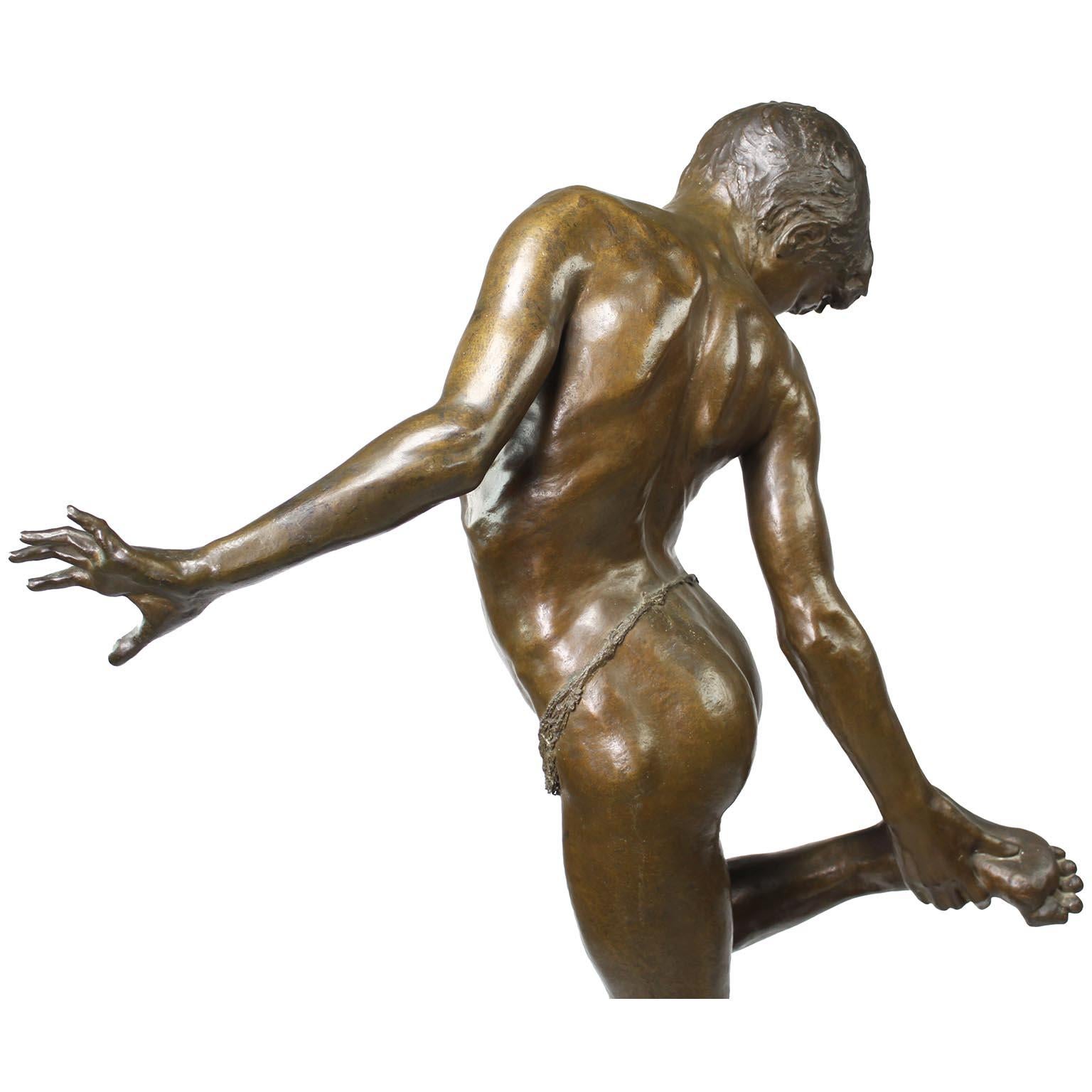 Figura de bronce de un niño pisando un cangrejo titulada 