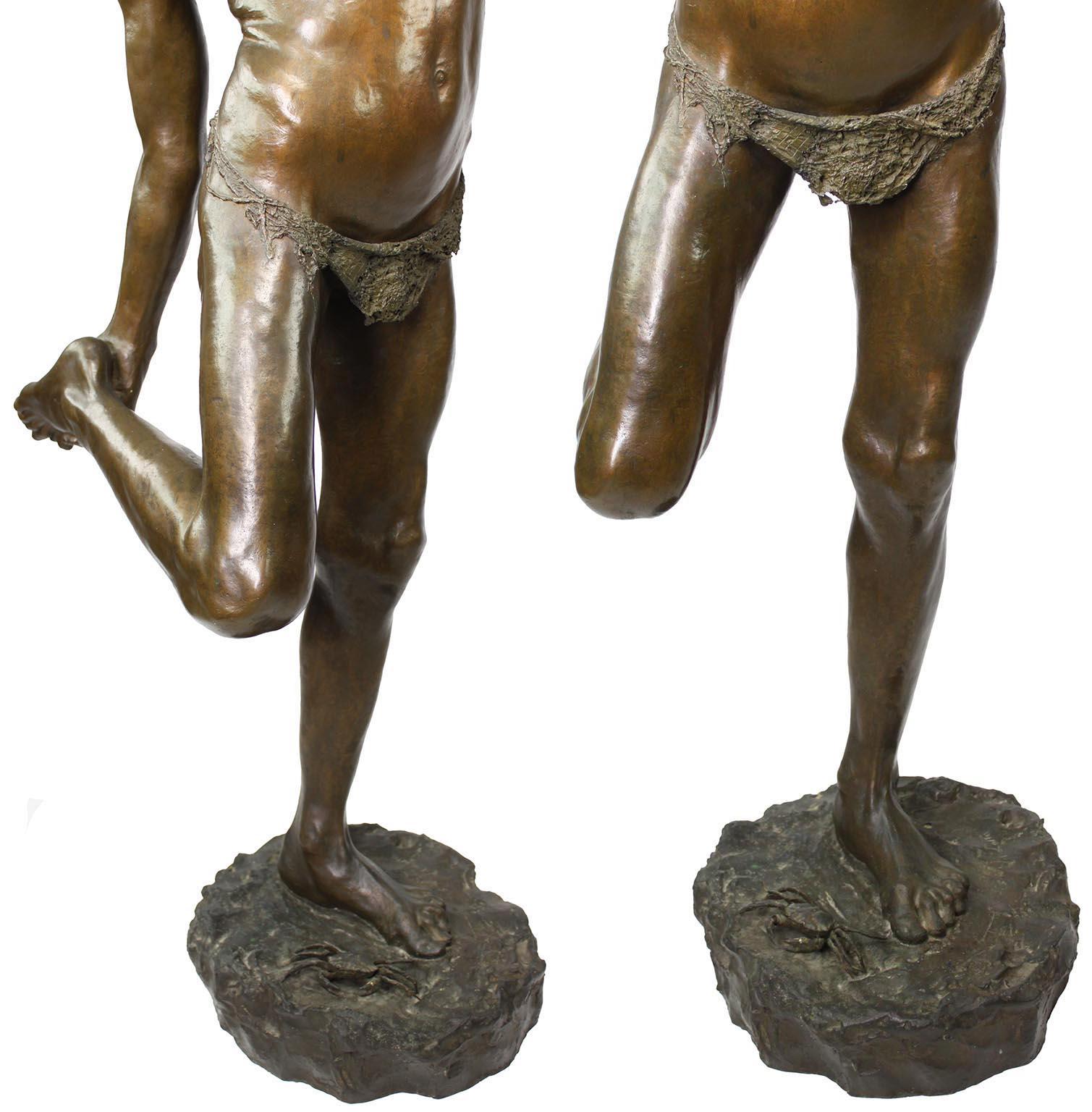 Figura de bronce de un niño pisando un cangrejo titulada 