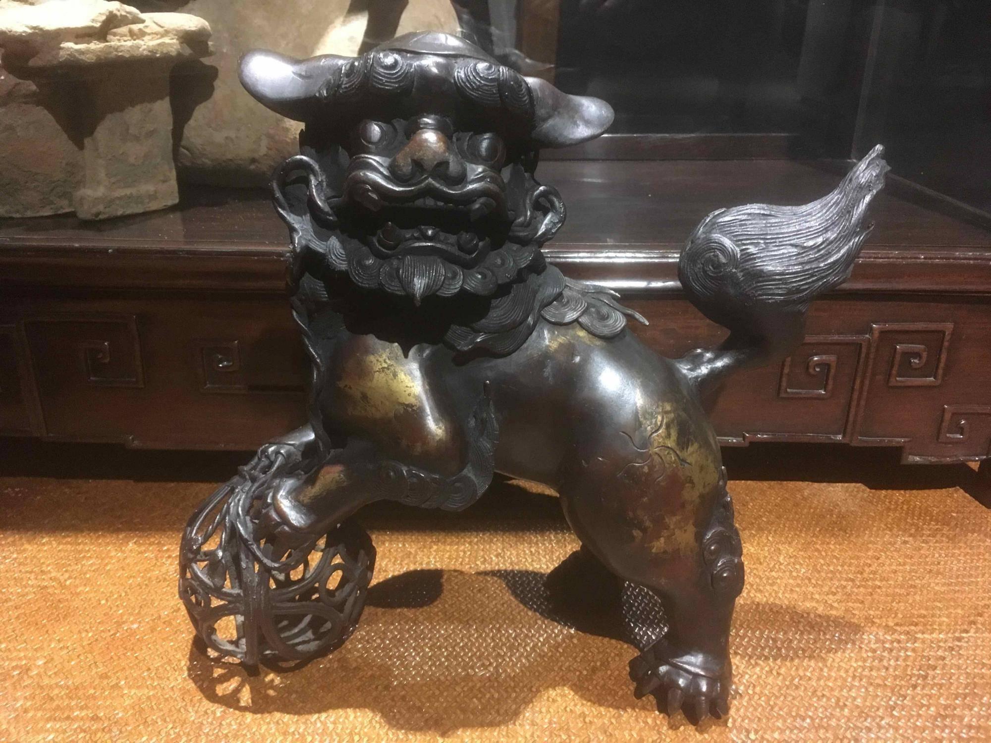 This lion dog is an incensor, where incense was inserted and burned inside. There is a door that opens on the back of the dog for the incense. The shish lion dog is a protector, often seen at entrances to protect the people within. 

Material: