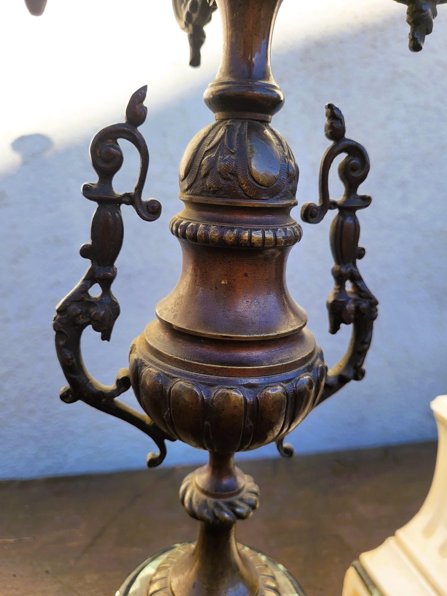 Bronze mantelpiece with brown patina and green and white marble.
It is composed of a clock with the allegory of agriculture and industry, and 2 candelabra, 5 lights each

Wear and tear on the patina, some chips on the marble, the glass of the dial