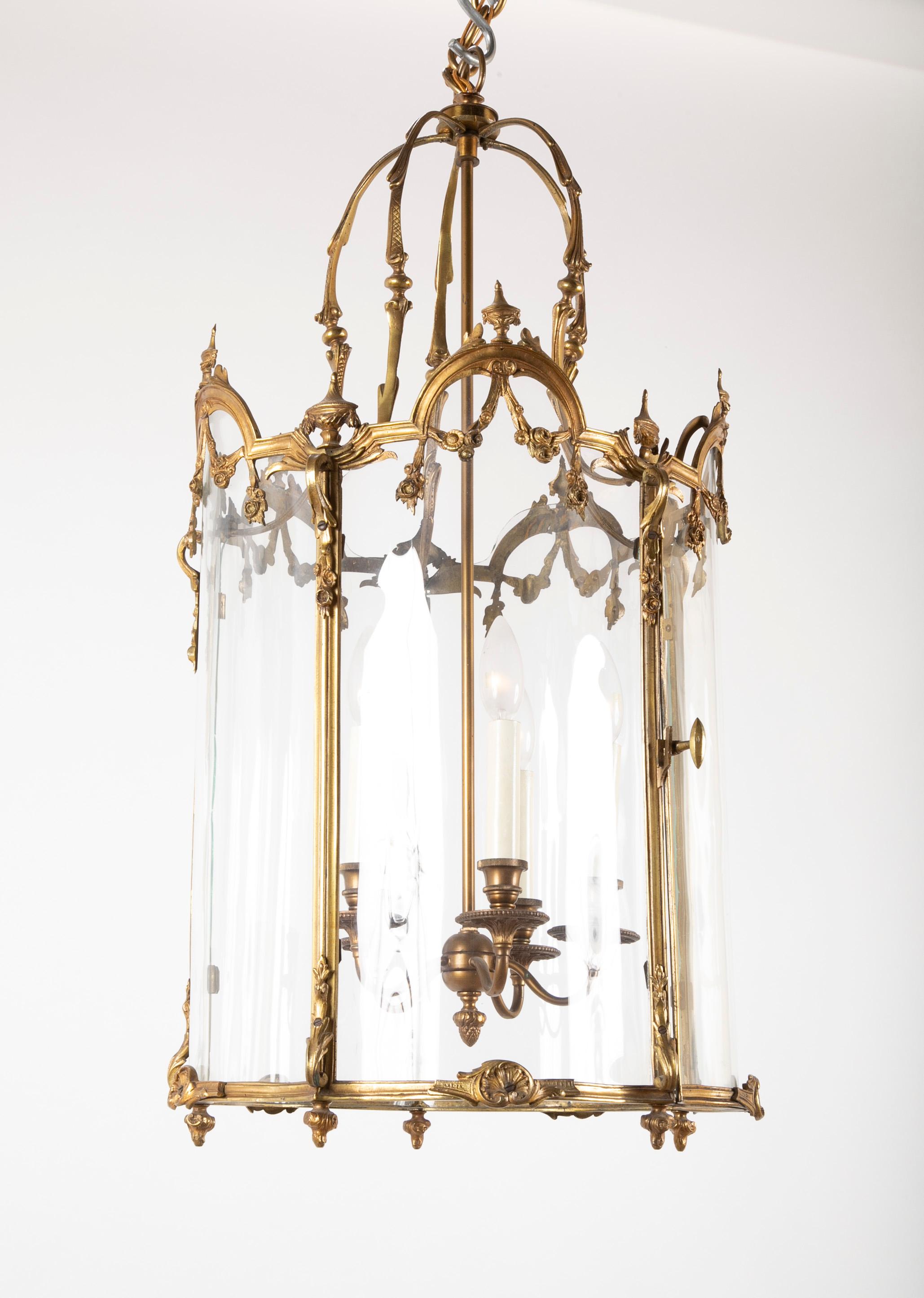 Bronze five-sided neoclassic form lantern with door, shaped glass and urn finials.