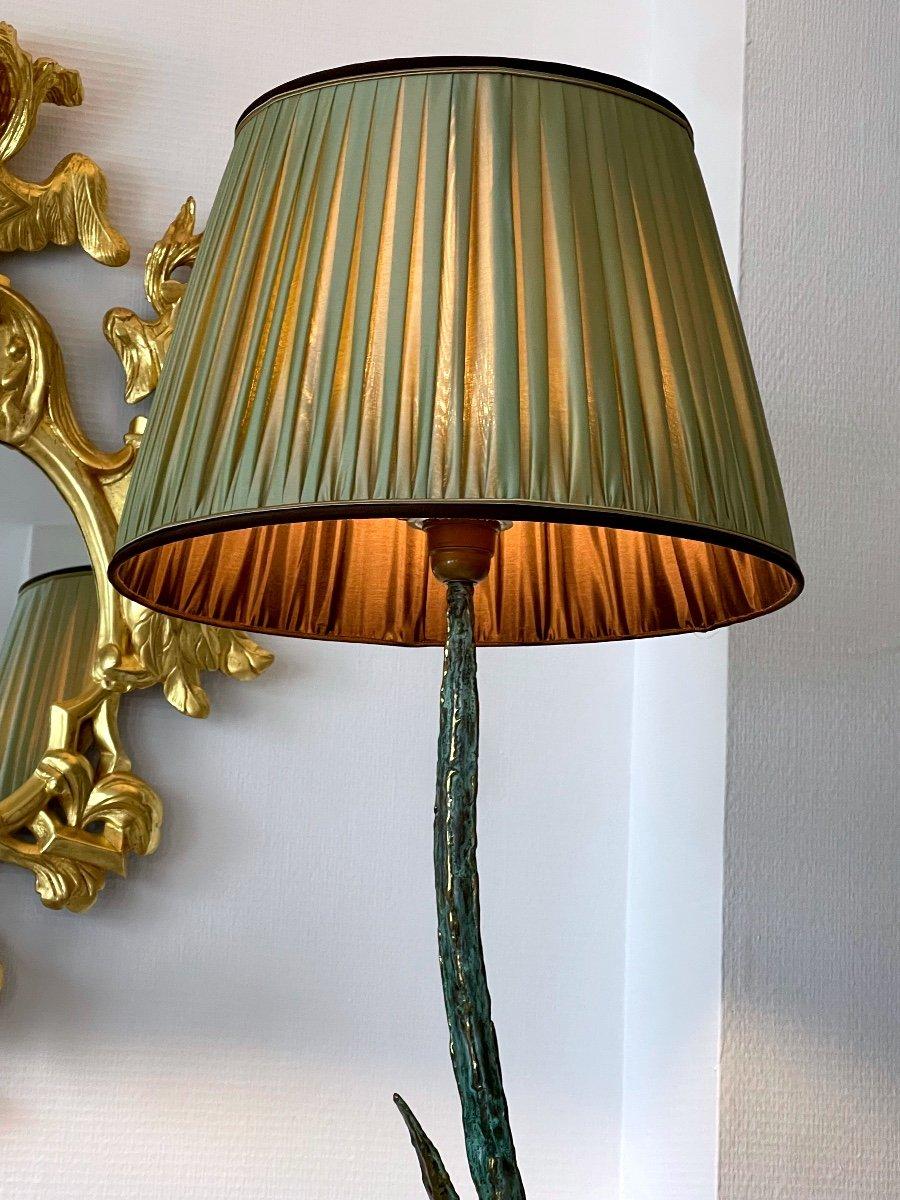 A beautiful floor lamp featuring a magnificent large heron in bronze with a double patina, brown and gilded, moving in a bed of reeds, its elegant and majestic gait magnifies the height of the foot equipped with a sublime pleated silk shade.

This