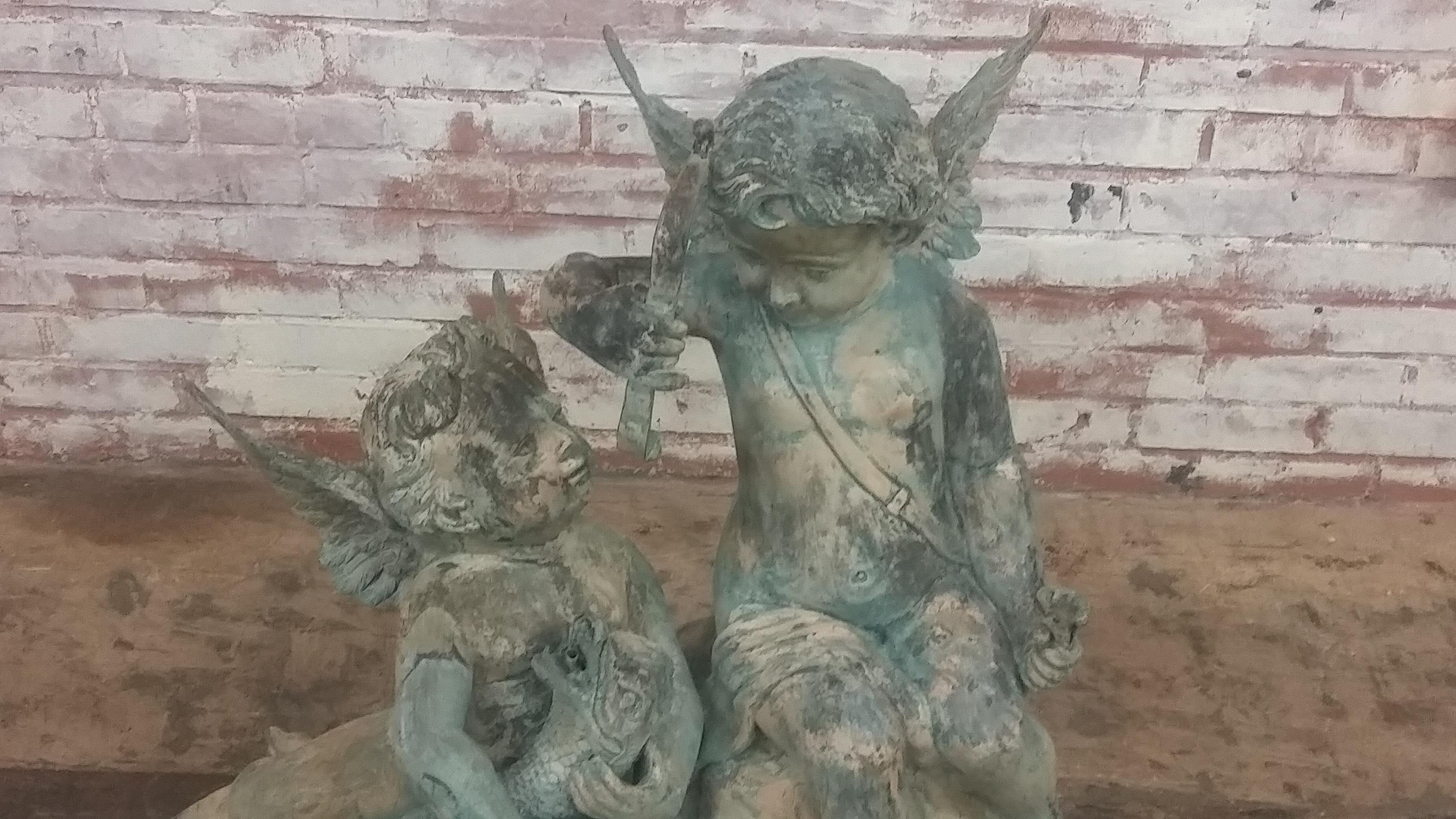Beautiful fountain figure (no basin) with great patina finish. A late 20th century reproduction. Two winged cherubs. One with a bow and the other holding a mythological dolphin. Great centerpiece for garden or property entrance.
