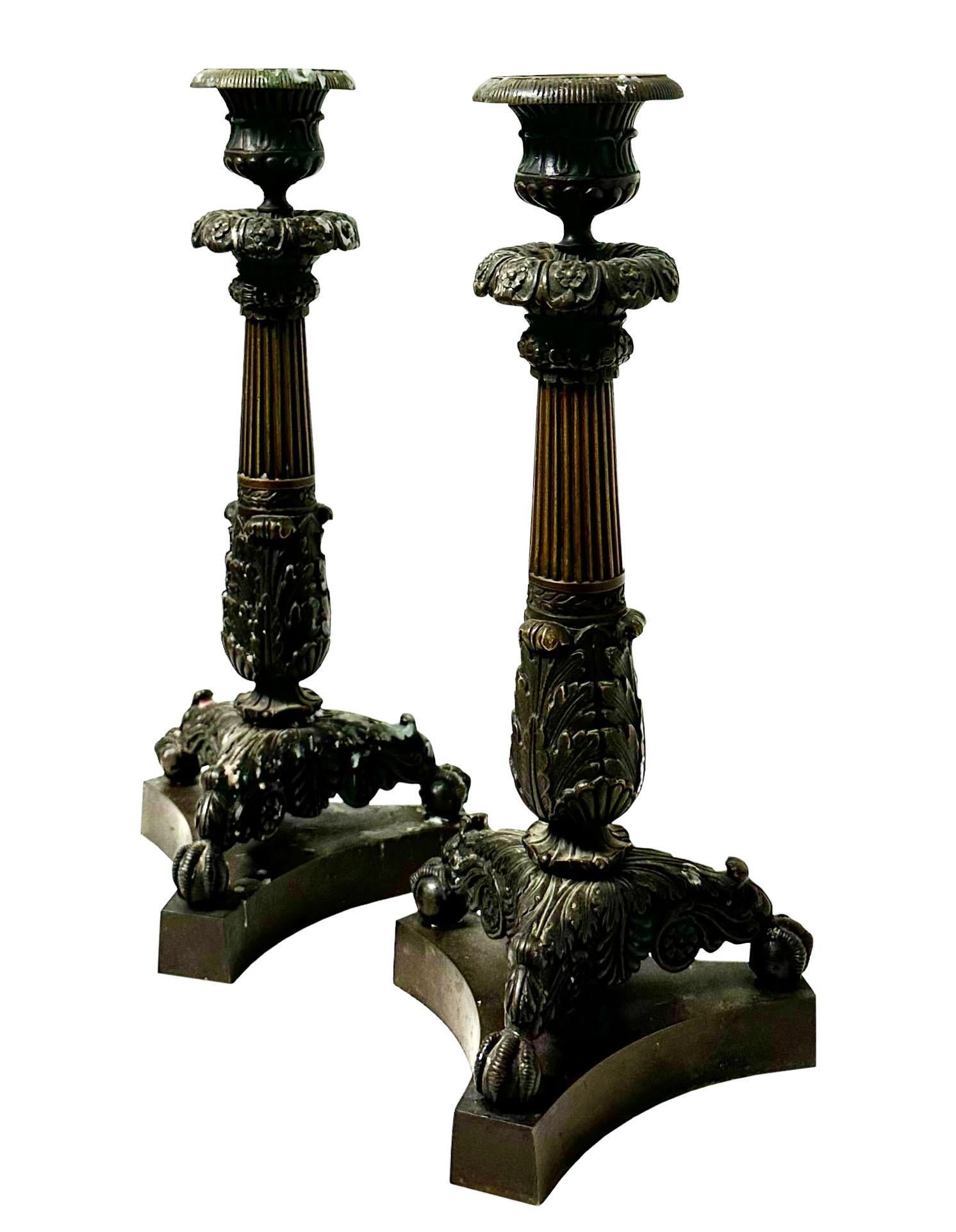 Ein Paar massiver französischer Kerzenleuchter aus dem frühen Kaiserreich mit dunkler Originalpatina. Sie sind in sehr gutem Zustand, originale Bogenschüsse. Das Einzige, was fehlt, ist ein Holzklotz unter einem von ihnen, den wahrscheinlich jemand