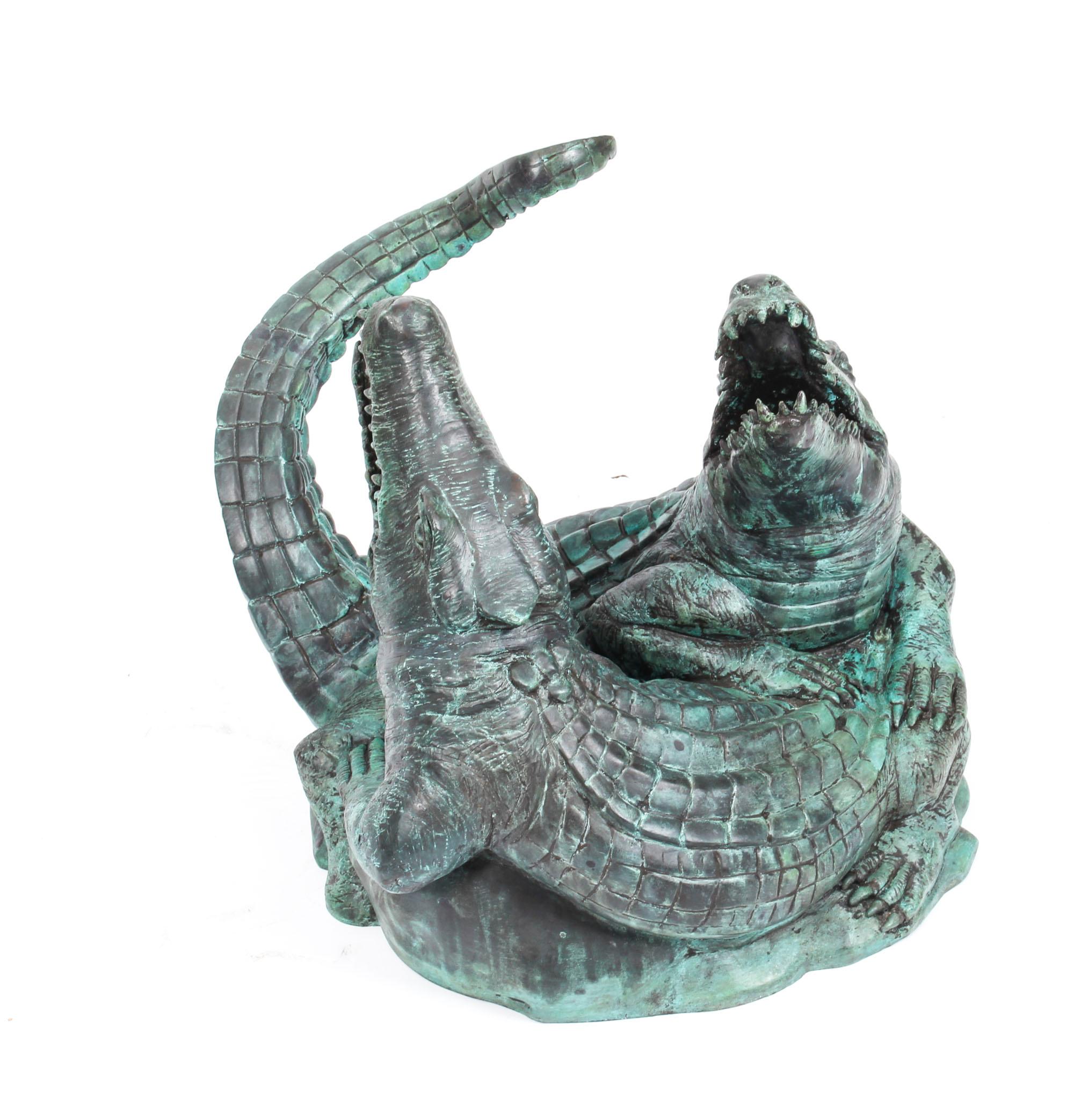This is an impressive bronze statue of two crocodiles, dating from the last quarter of the 20th century.

This life-like bronze statue features two crocodiles with their jaws open on the hunt for food and their bodies interviewed. 
 
Equally at home
