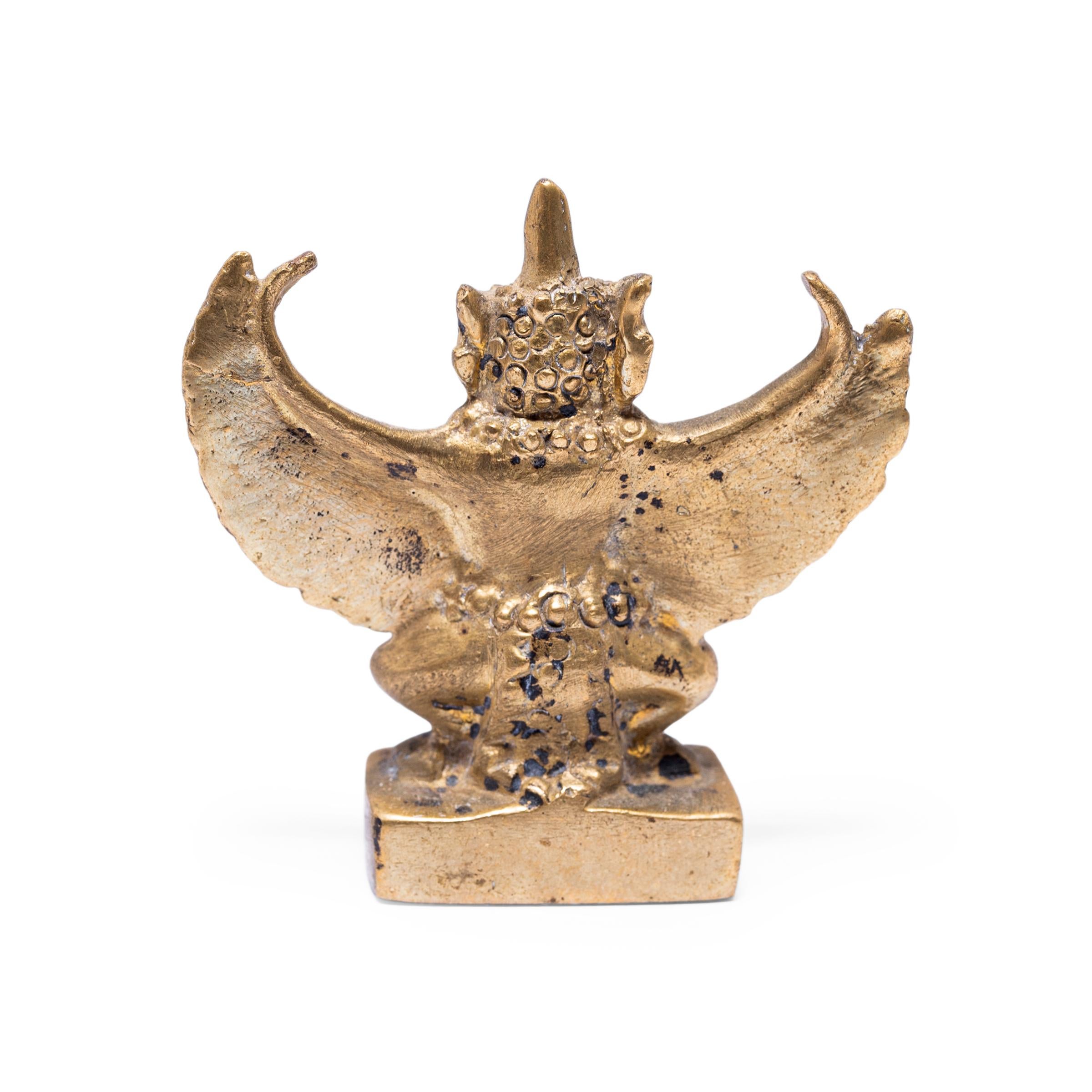 This petite bronze figurine is cast in the form of Garuda, a demigod and mythical king of birds in Hindu and Buddhist faith. Taking the form of half-bird half man, Garuda is a powerful protector and ever-watchful enemy of the serpent. Garuda is