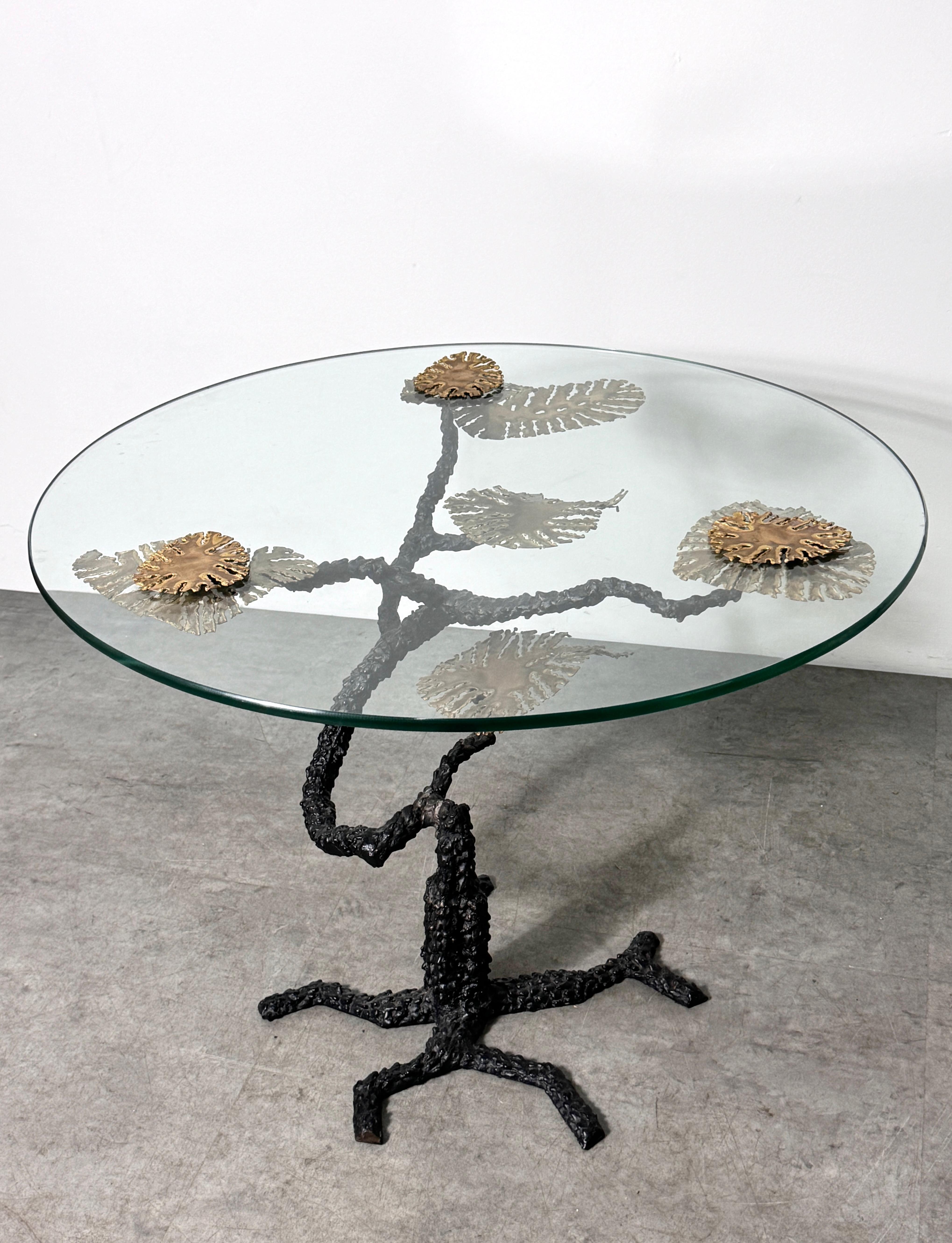 Unique sculptural bronze and glass side table in the style of Silas Seandel

Bronze bonsai tree style base with brass leaf accents and a round glass top secured with brass leaf finials

30