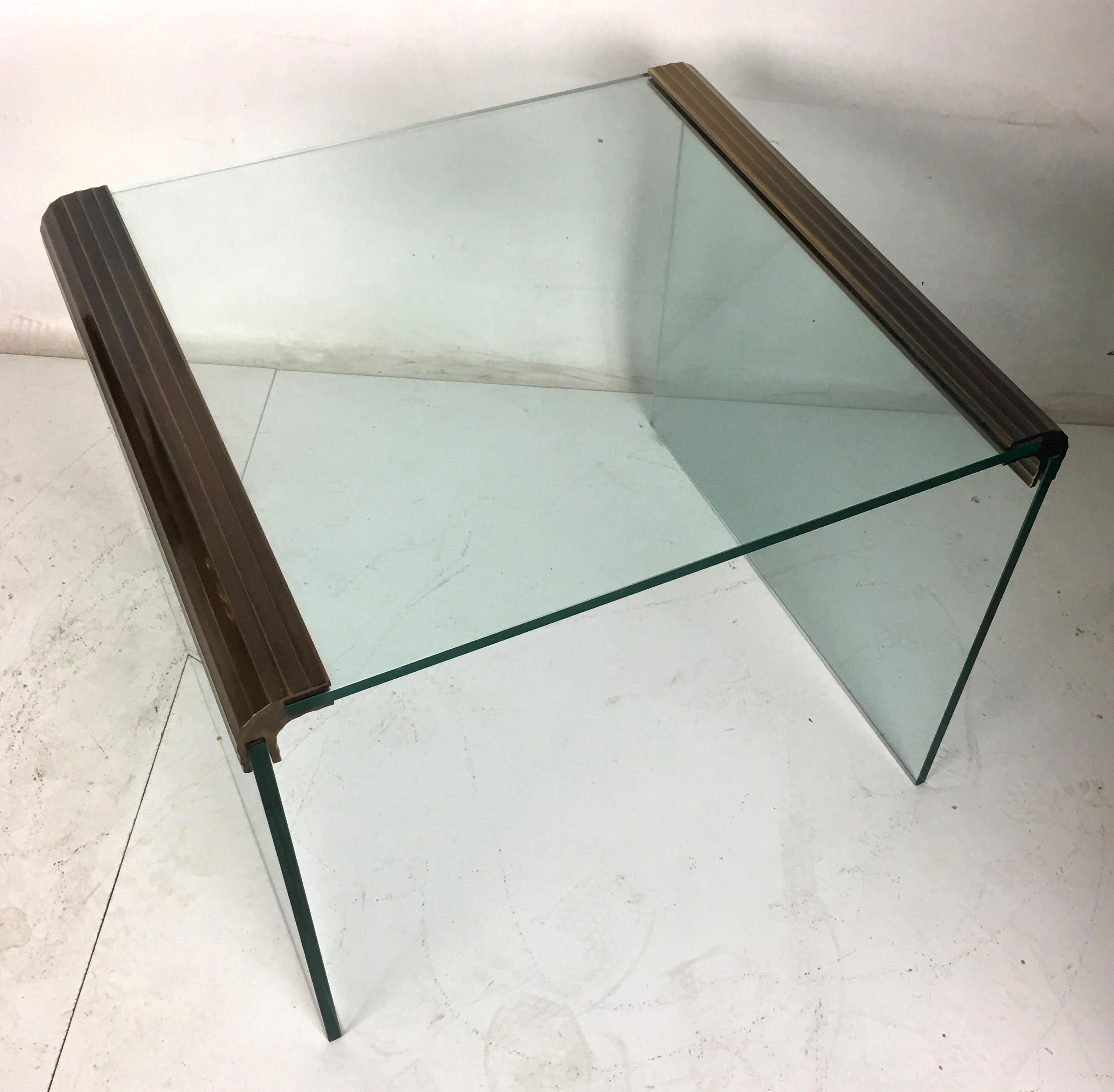 Stylish 1980s Waterfall side table with scalloped bronze fixtures securing thick glass by Pace collection.