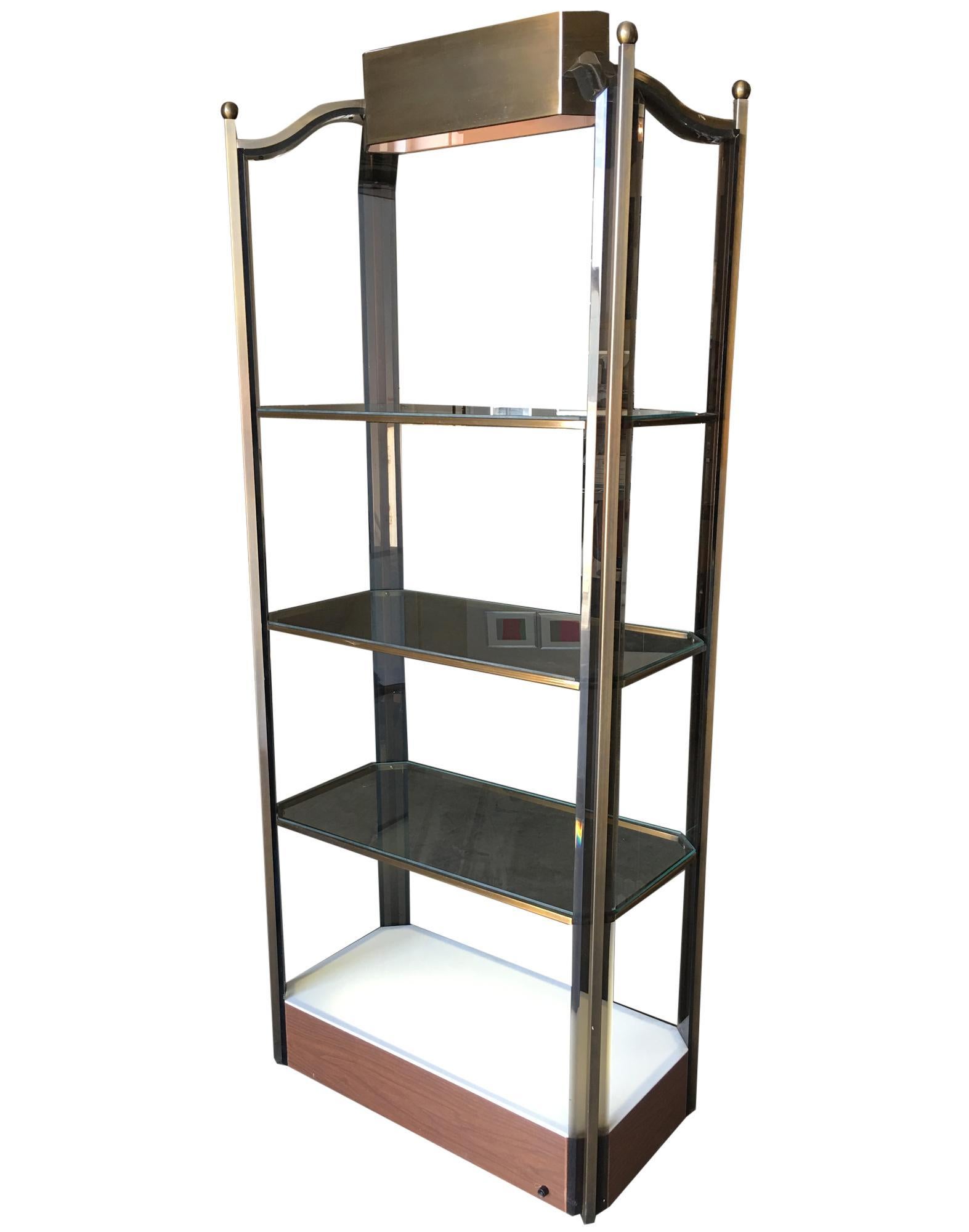Vintage Disco era glass light-up etagere with bronze wash frame and smoked acrylic accents. The shelf features a unique light-up base and a large spotlight on the top. This piece is in excellent condition. Circa 1970s.

Dimensions: 79