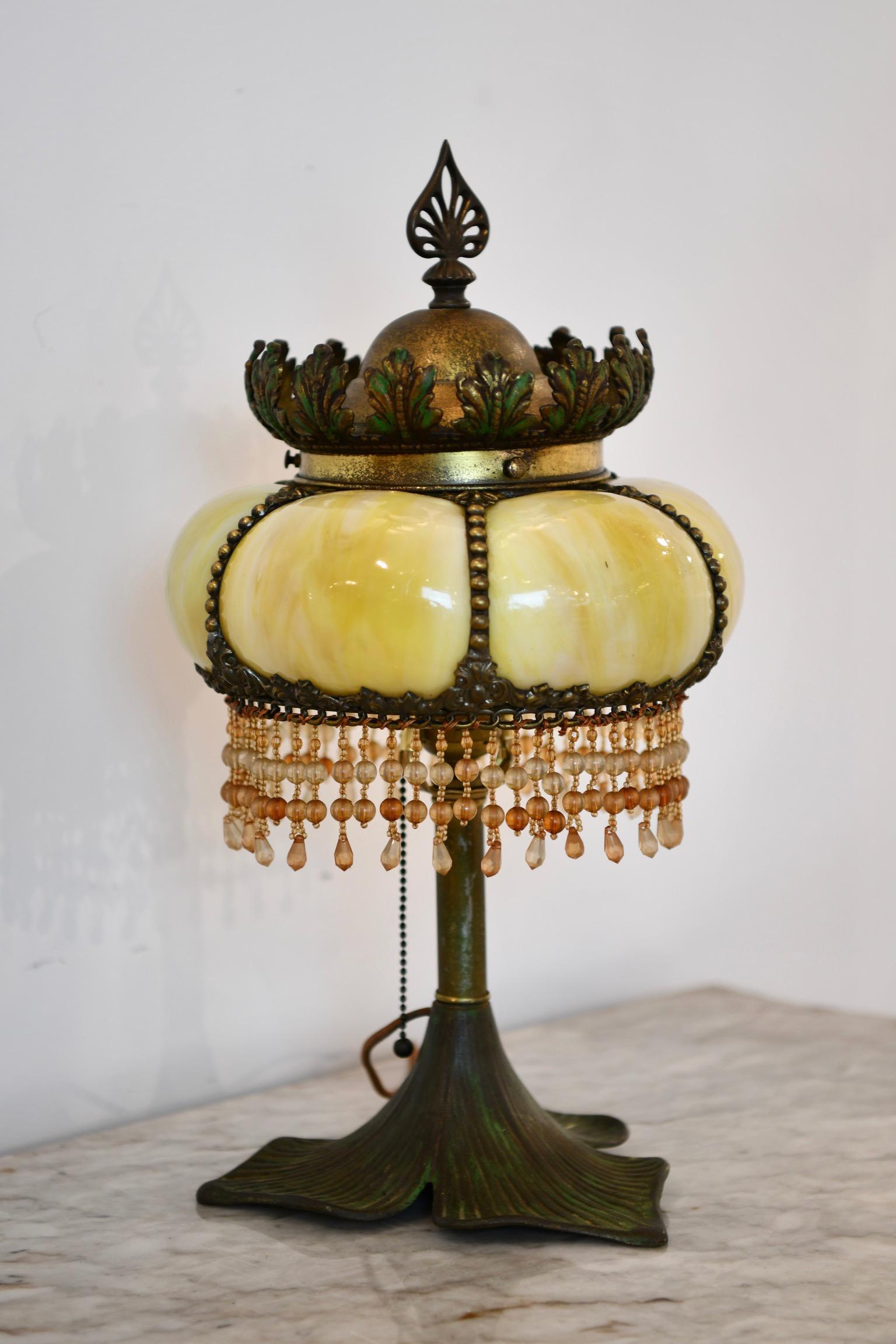 Bronze leaf form base with blown out glass shade with hanging beads and bronze crown. Dimensions: 10