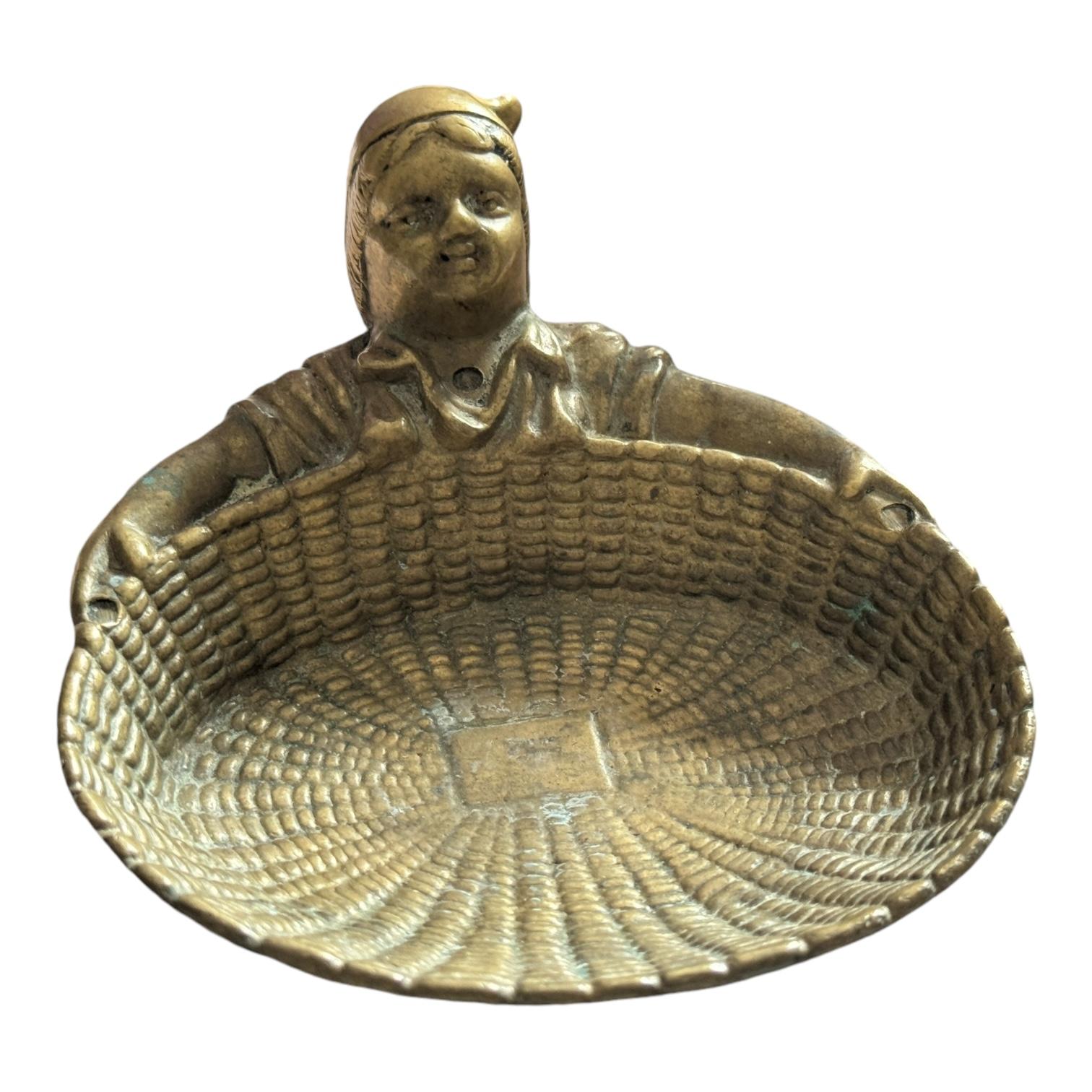 A lovely and unusual vintage solid bronze trinket dish or tray formed of a basket (cast to look like wicker) being held in the outstretched arms of a woman, ideal for keeping coins, small trinkets or just to present your business cards. Would say it