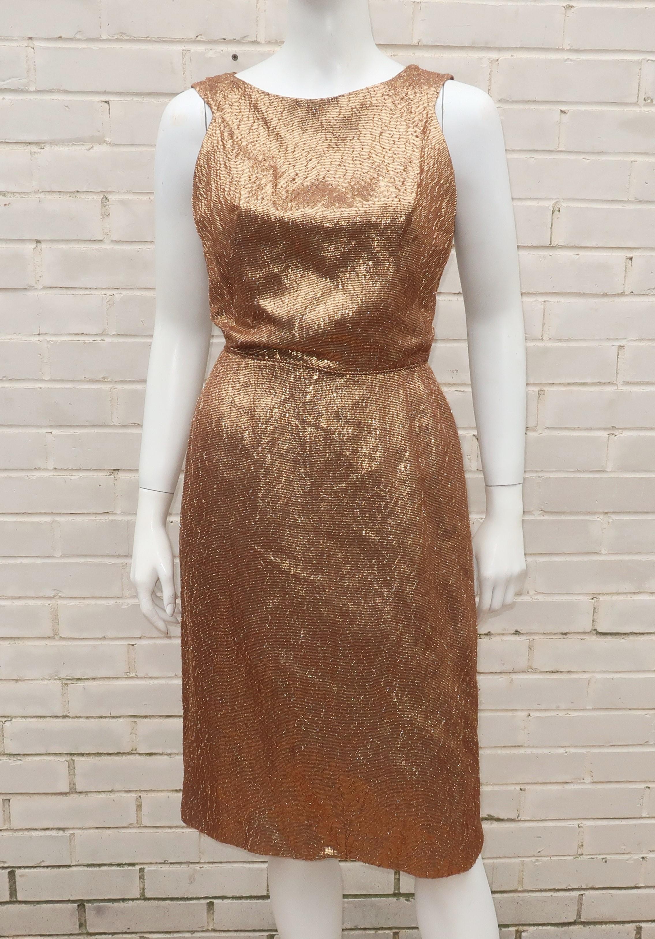 1950's bronzed gold textured lamé wiggle dress with a sassy cut out design at the back accented by bows.  The sleeveless silhouette zips, hooks and snaps at the back with a cord detail at the waistline.  Fully lined in a brown acetate.  No designer