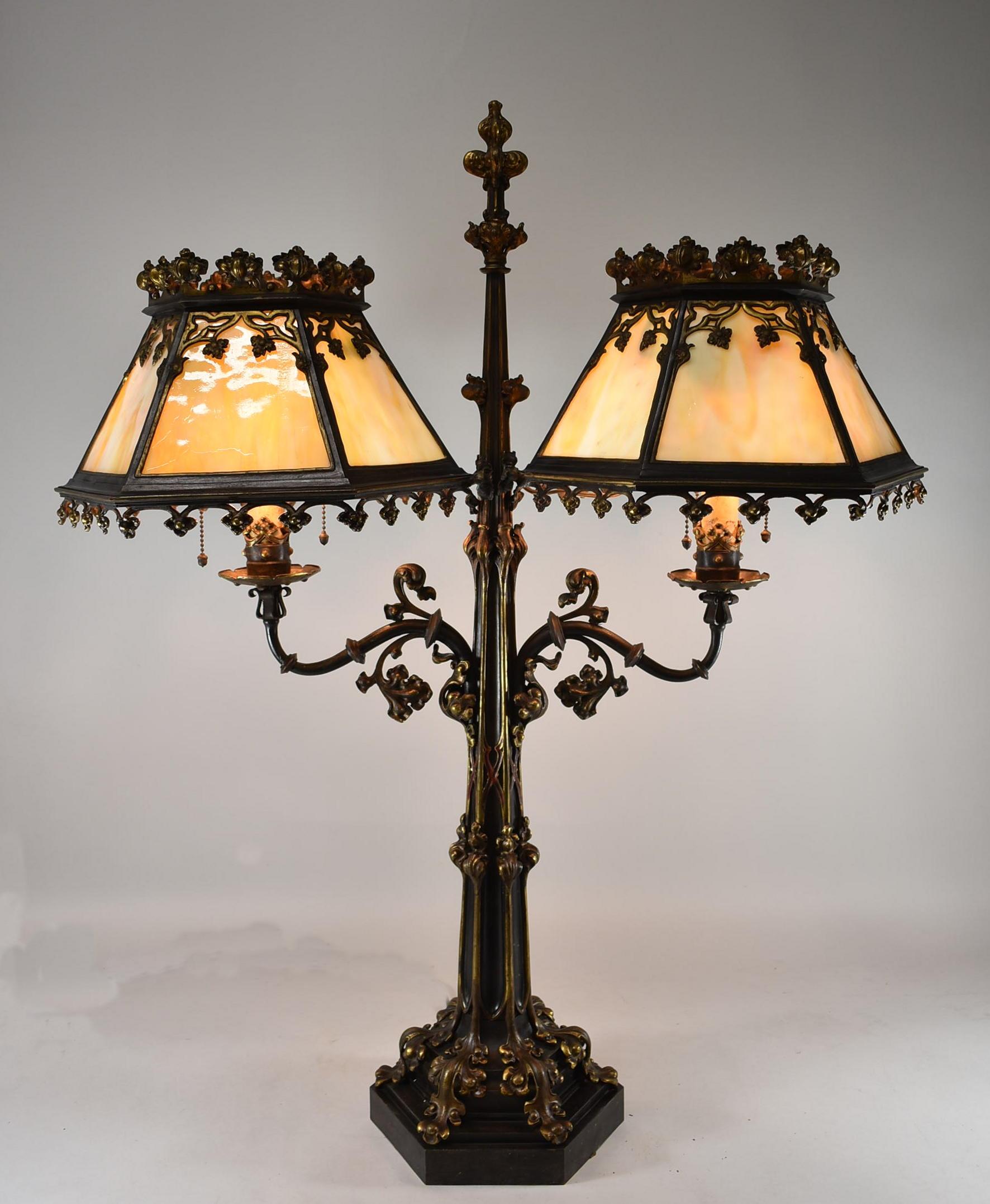 Antique bronze Gothic Revival double amber slag glass shaded library table lamp. Three sockets each side with acorn pull chains. No cracks in the glass. Heavy with intricate detailing. Has been rewired.