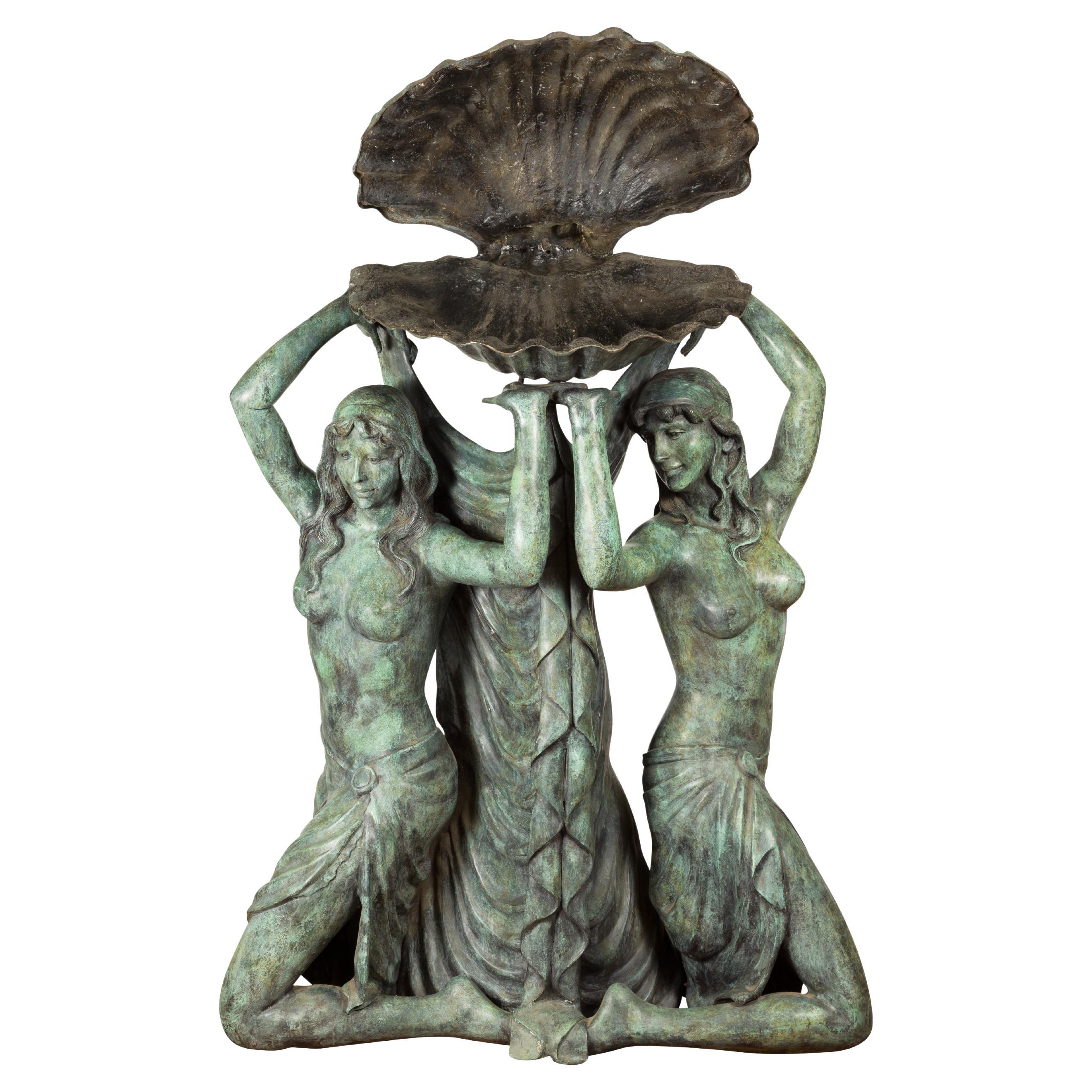 Fontaine en bronze d'inspiration gréco-romaine représentant trois nymphes tenant un coquillage en vente