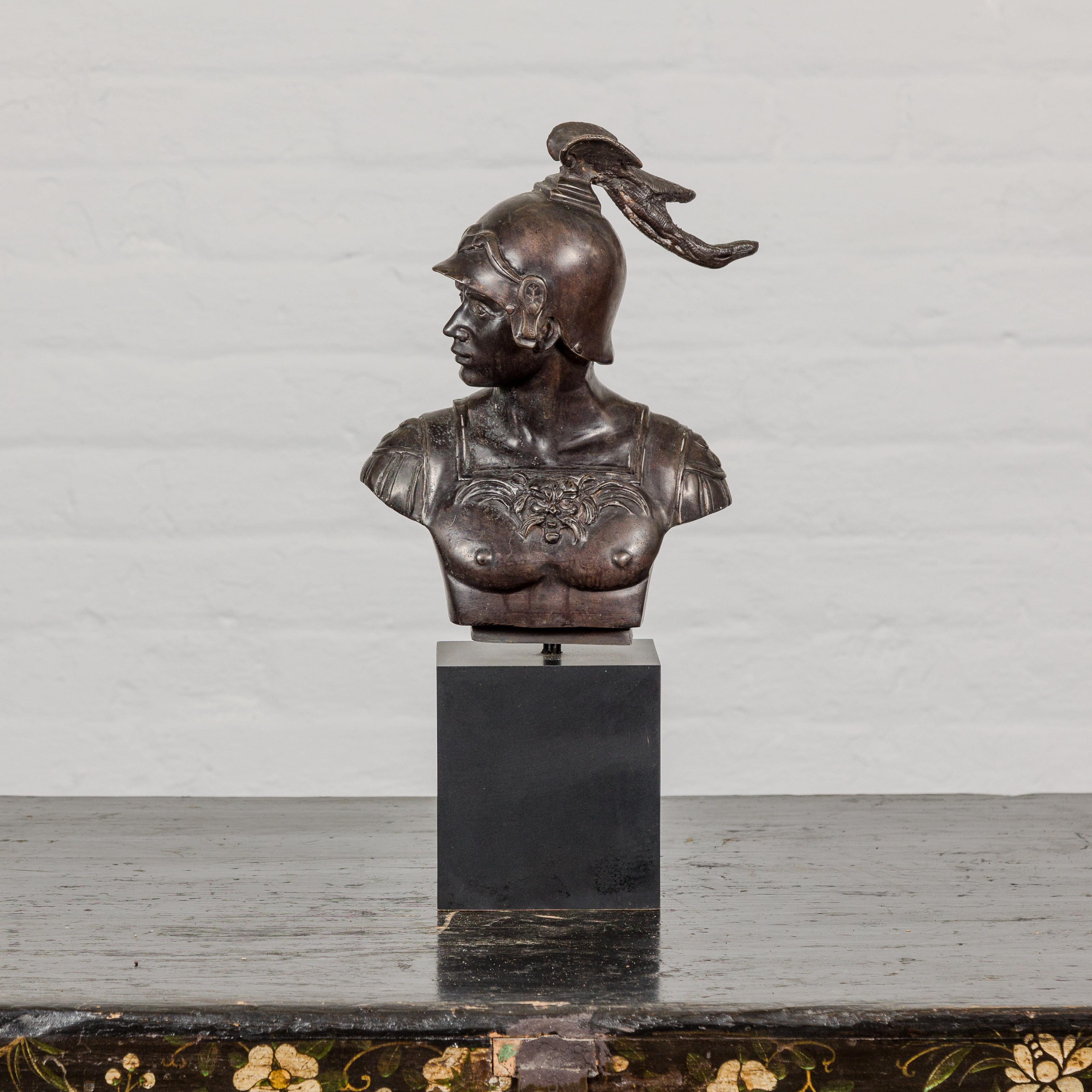 A Greco Roman style bronze buste depicting a Spartan soldier on black wooden base. This Greco Roman style bronze bust, masterfully depicting a Spartan soldier, is a striking piece that exudes strength and classical beauty. Created using the lost wax