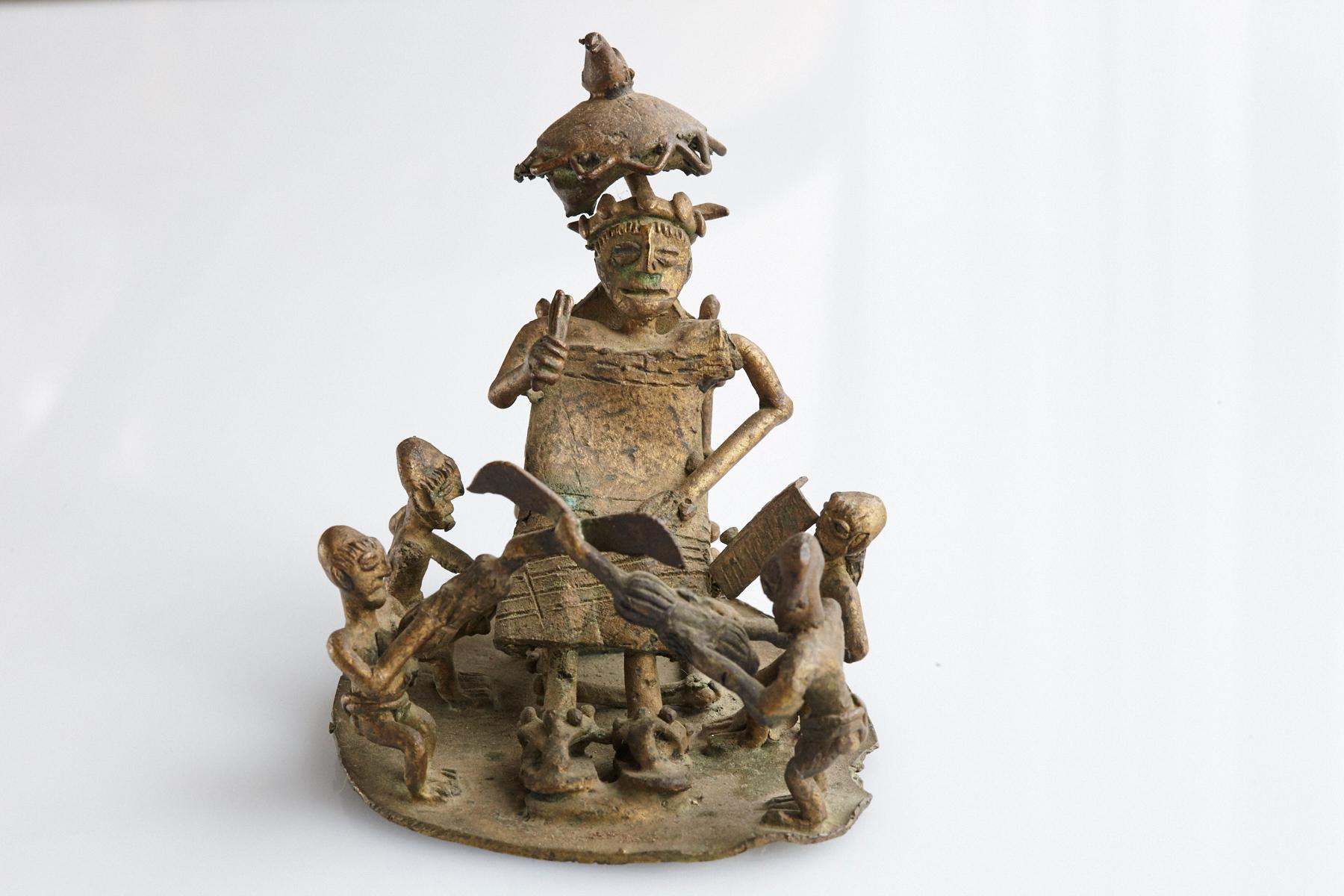 Eine gegossene Bronzegruppe, die einen Stammeshäuptling (König) mit seinen Dienern darstellt. Ein Musiker mit einer Trommel, eine Person mit einem Palmblatt, eine andere mit einem Regenschirm, um Schatten zu spenden, und zwei Wächter mit gekreuzten