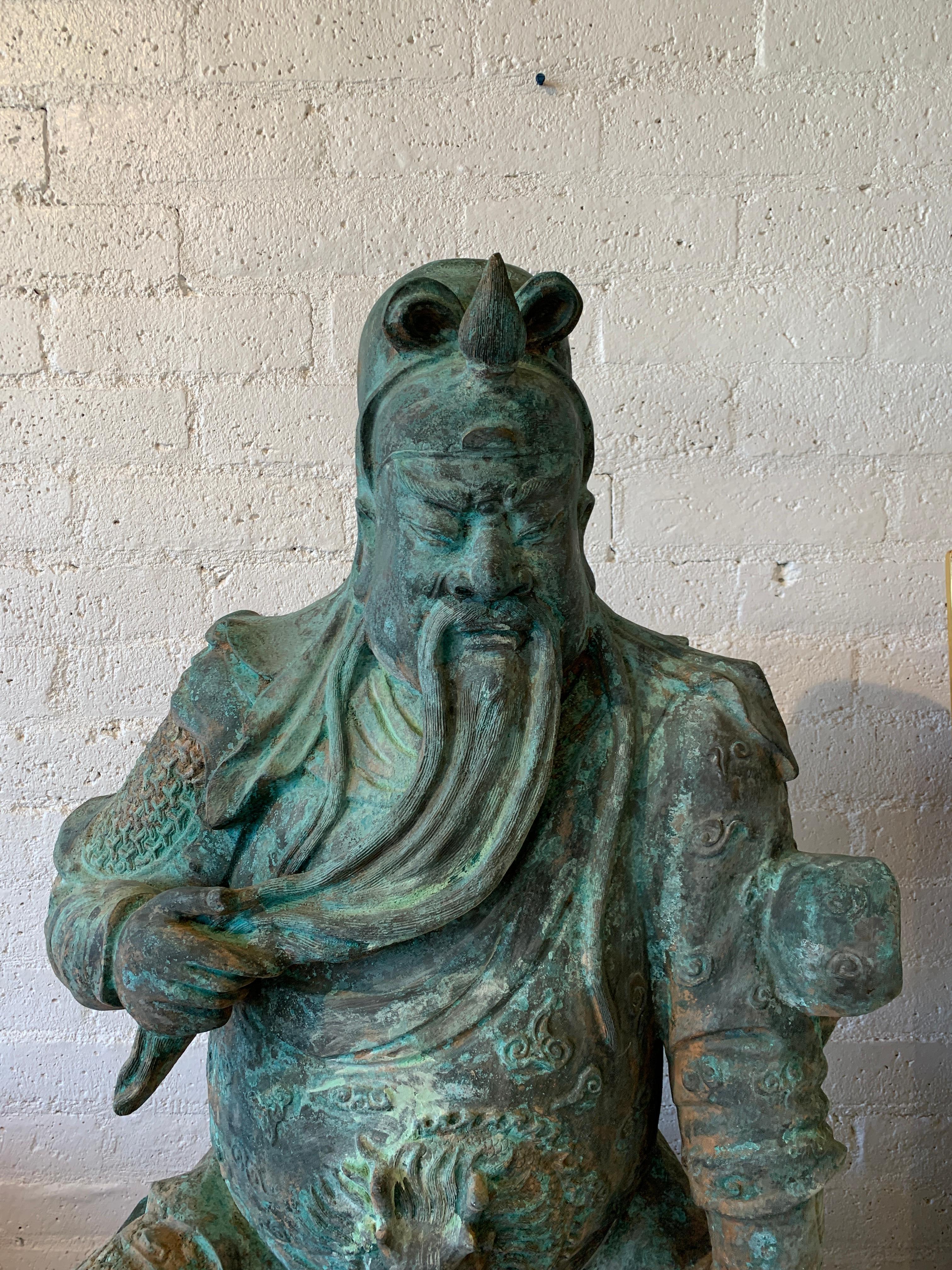 A massive larger than life size bronze seated figure of Guan Yu one of the most documented figures in Asian history. It has been sitting in a garden and has fabulous greenish patina. Nice detail and scale. In good condition with some imperfections