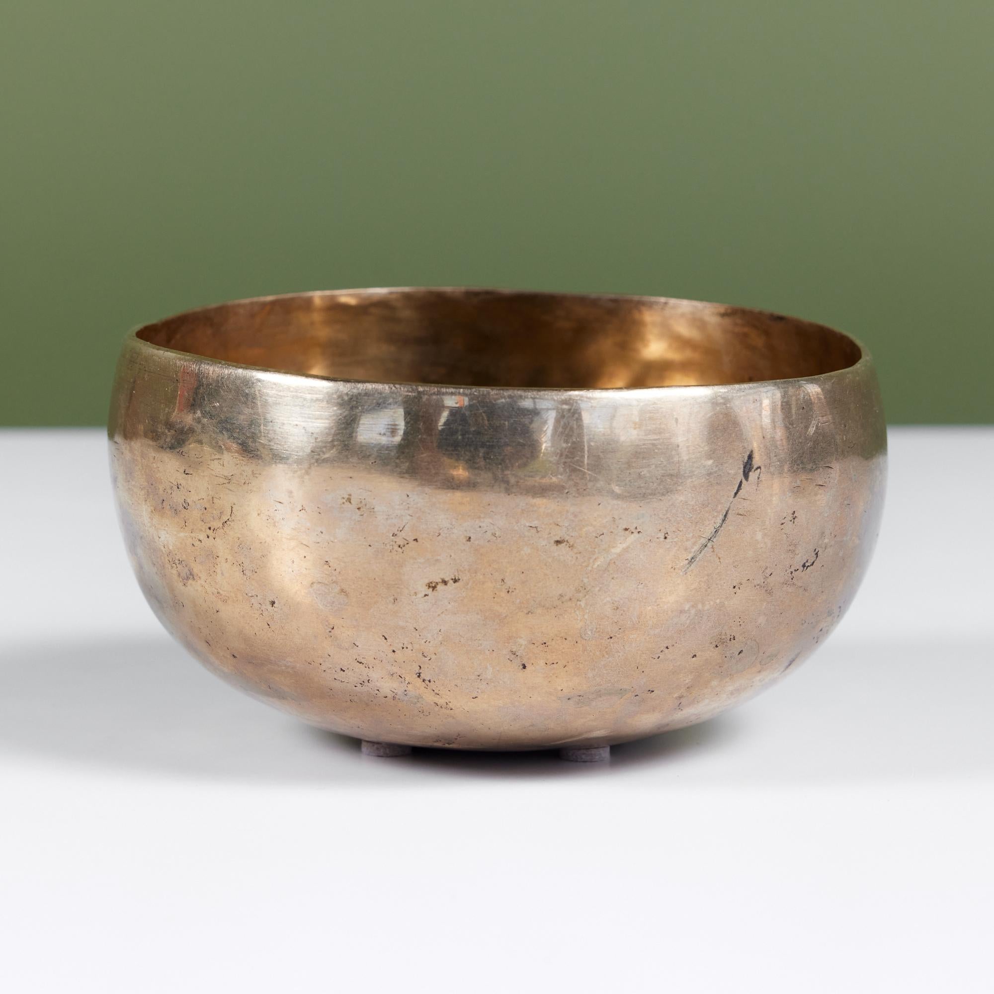 Patinated bronze bowl with a rounded lip and hammered body featuring Tibetan script. You can bring out higher tones in the bowl by using a mallet around the rim. It can also be used as catchall for your pocket objects, or just a bold decorative