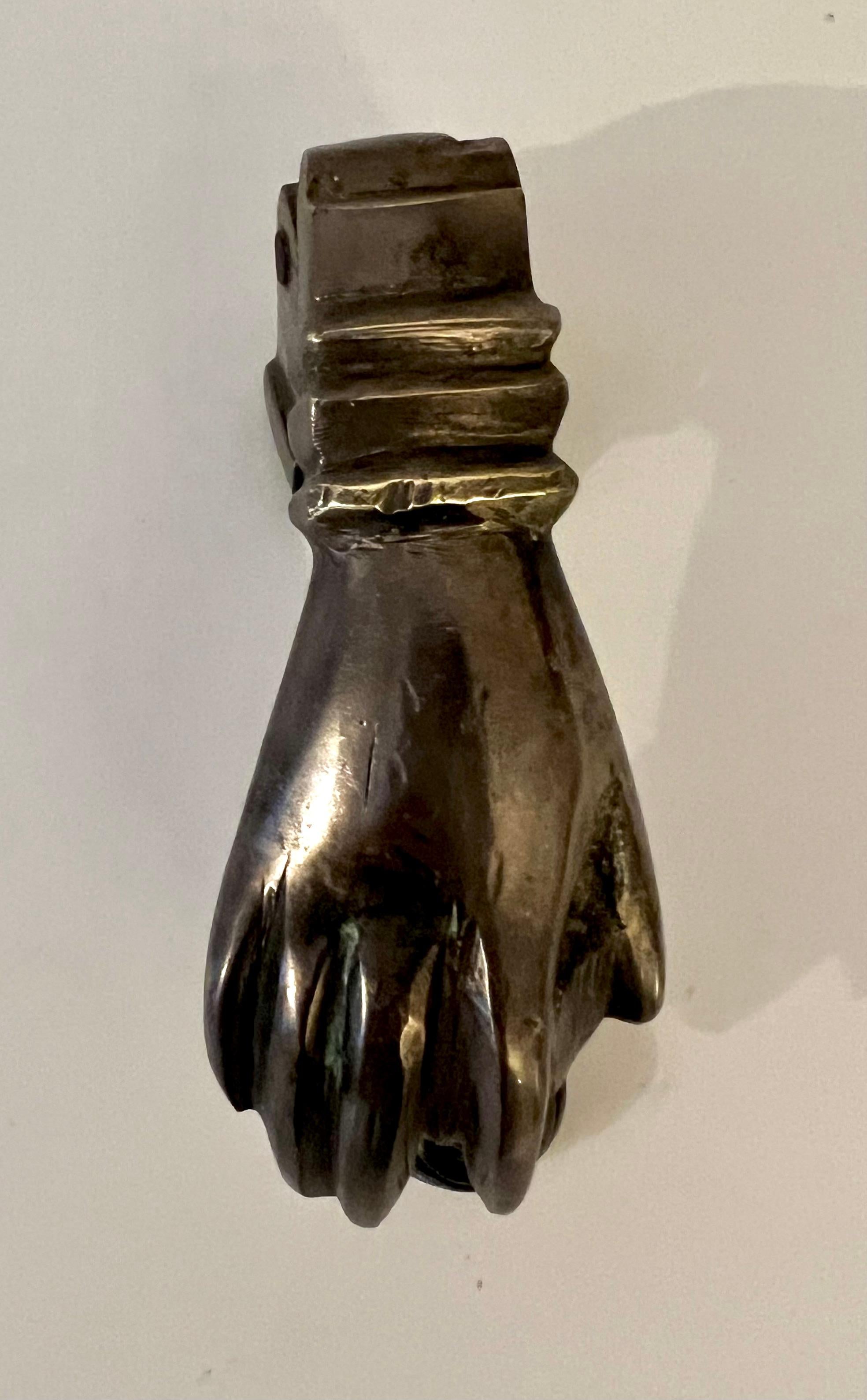 A wonderful door knocker in the shape of a hand. The solid bronze piece is petite and comes with the strike... prepared to go through a 2