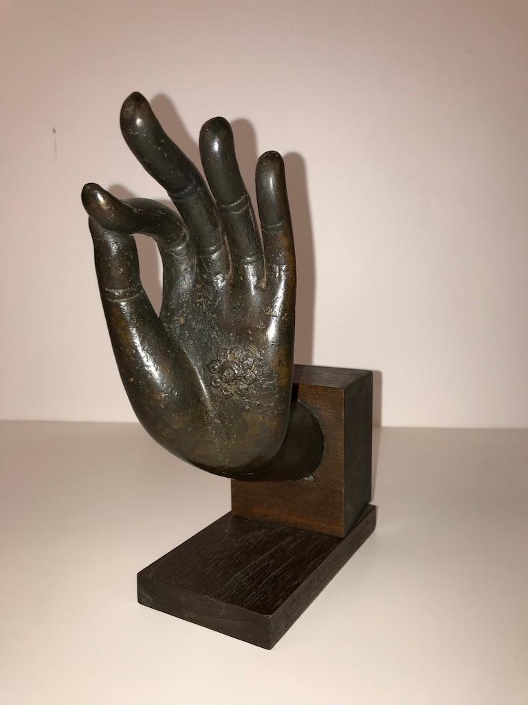 Beautifully realized bronze hand of Buddha, in the Vitarka mudra, mounted on a walnut base. Rich dark chocolate patina. 19th century, possibly earlier. Great gift for the yogi in your life.
 
The Vitarka mudra symbolizes teaching and discussion.