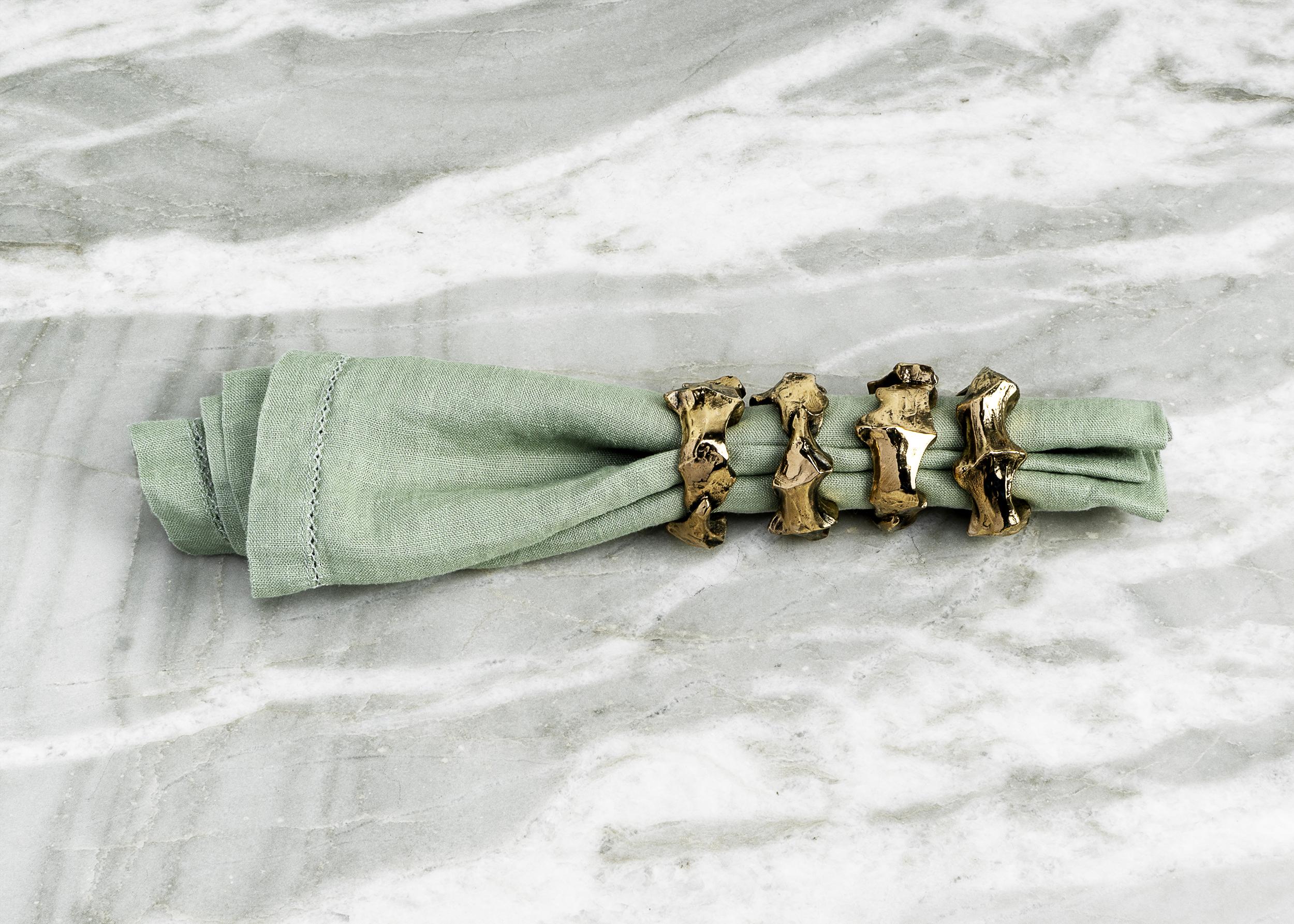 The Di Mano Napkin Rings by artist Tom Bollinger are a striking blend of art and function, designed to elevate the dining experience. Each napkin ring is handcrafted in bronze and finished with a high-polished surface that highlights its sculptural