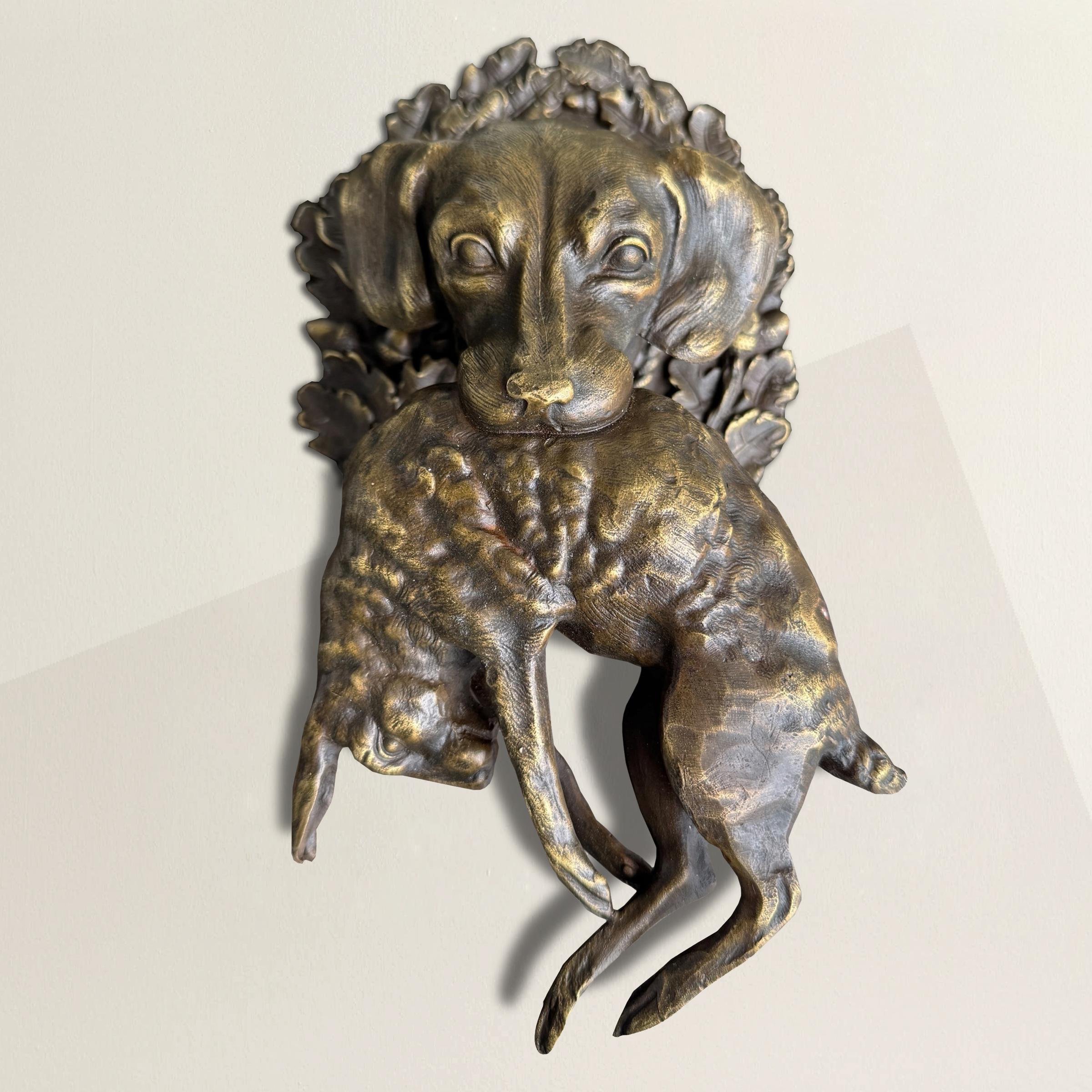 Ce chien de chasse en bronze moulé, avec un lièvre pris délicatement dans ses mâchoires, semble sorti des murs d'un pavillon de chasse français imaginaire - ou mieux encore, des salles oniriques du Musée de la Chasse et de la Nature à Paris, où