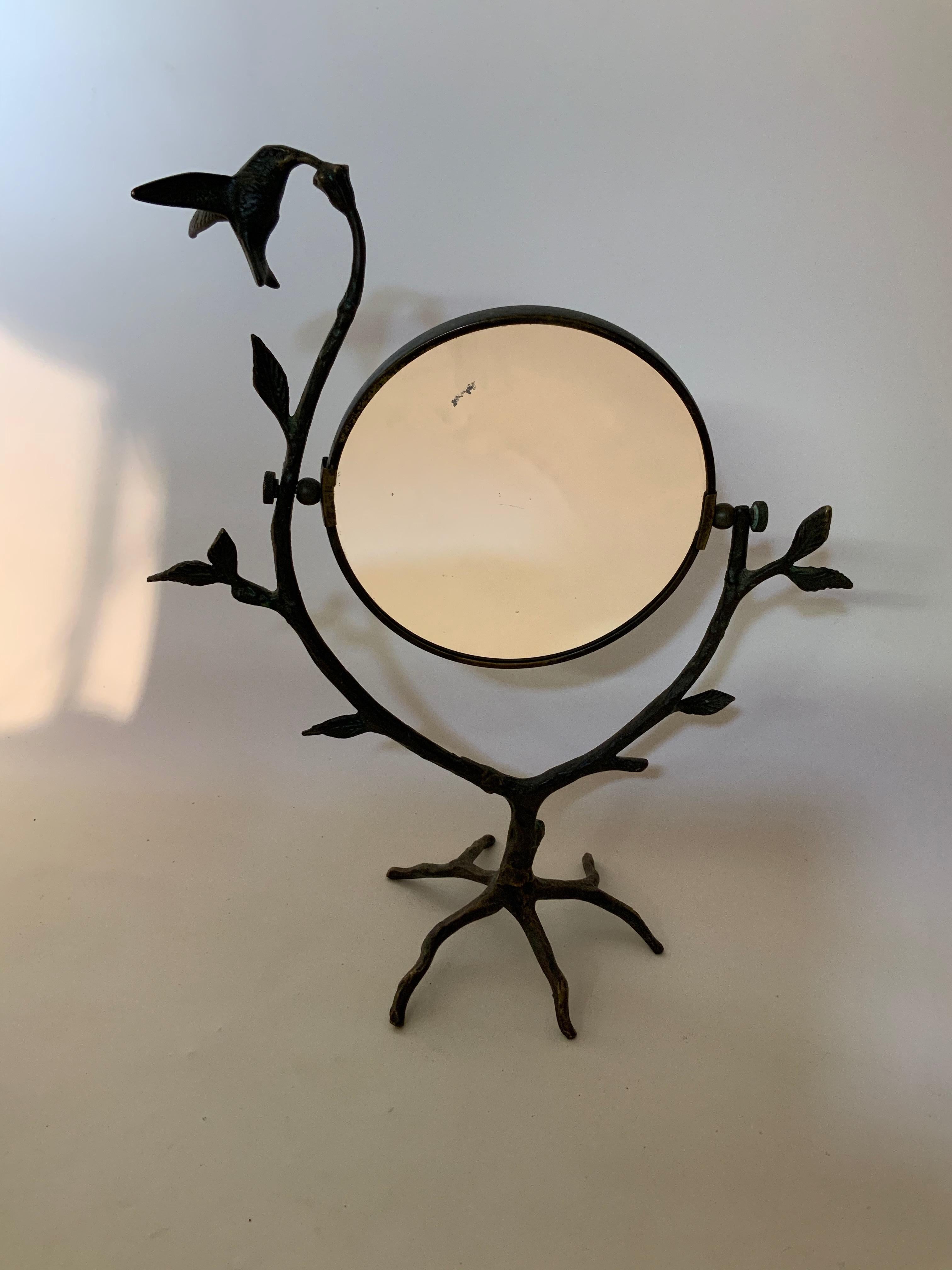 Unique cast bronze tabletop mirror in the matter of Giacometti. This beautiful tabletop mirror features a leaf and branch base with a hummingbird. The mirror can be angled and adjusted, circa 1960-1970. Placement in your entryway, vanity, bedroom,