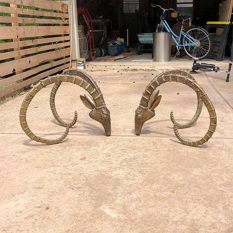 Pair of solid bronze ibex heads attributed to Alain Chervet. They form the base of a cocktail table with a heavy glass top. Top measures 30