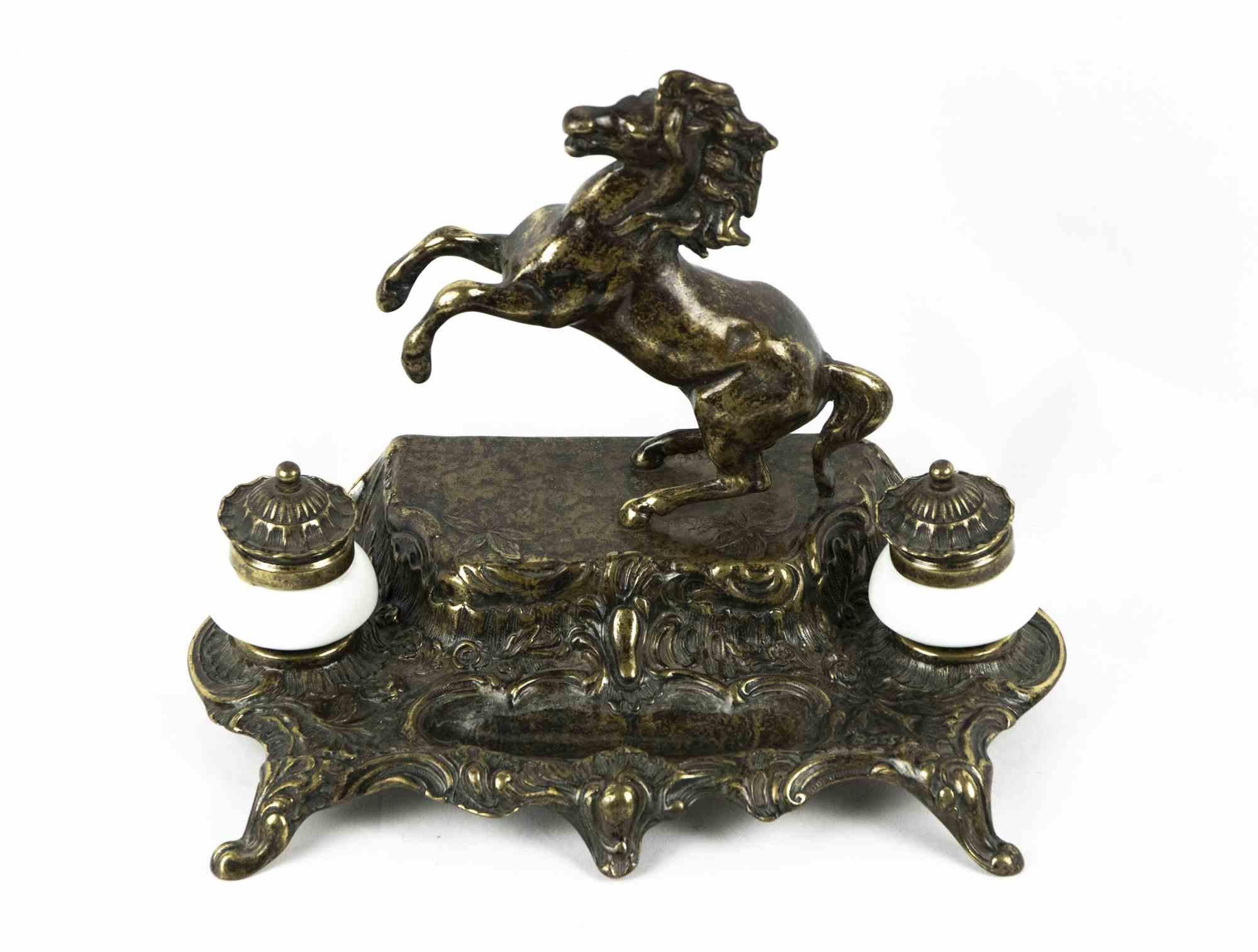 Das Bronze-Tintenfass ist ein originelles Dekorationsobjekt aus der Mitte des 20. Jahrhunderts.

Ein sehr elegantes Bronzetintenfass, das mit einem aufsteigenden Pferd verziert ist. Enthält ein paar Tintenfässer.