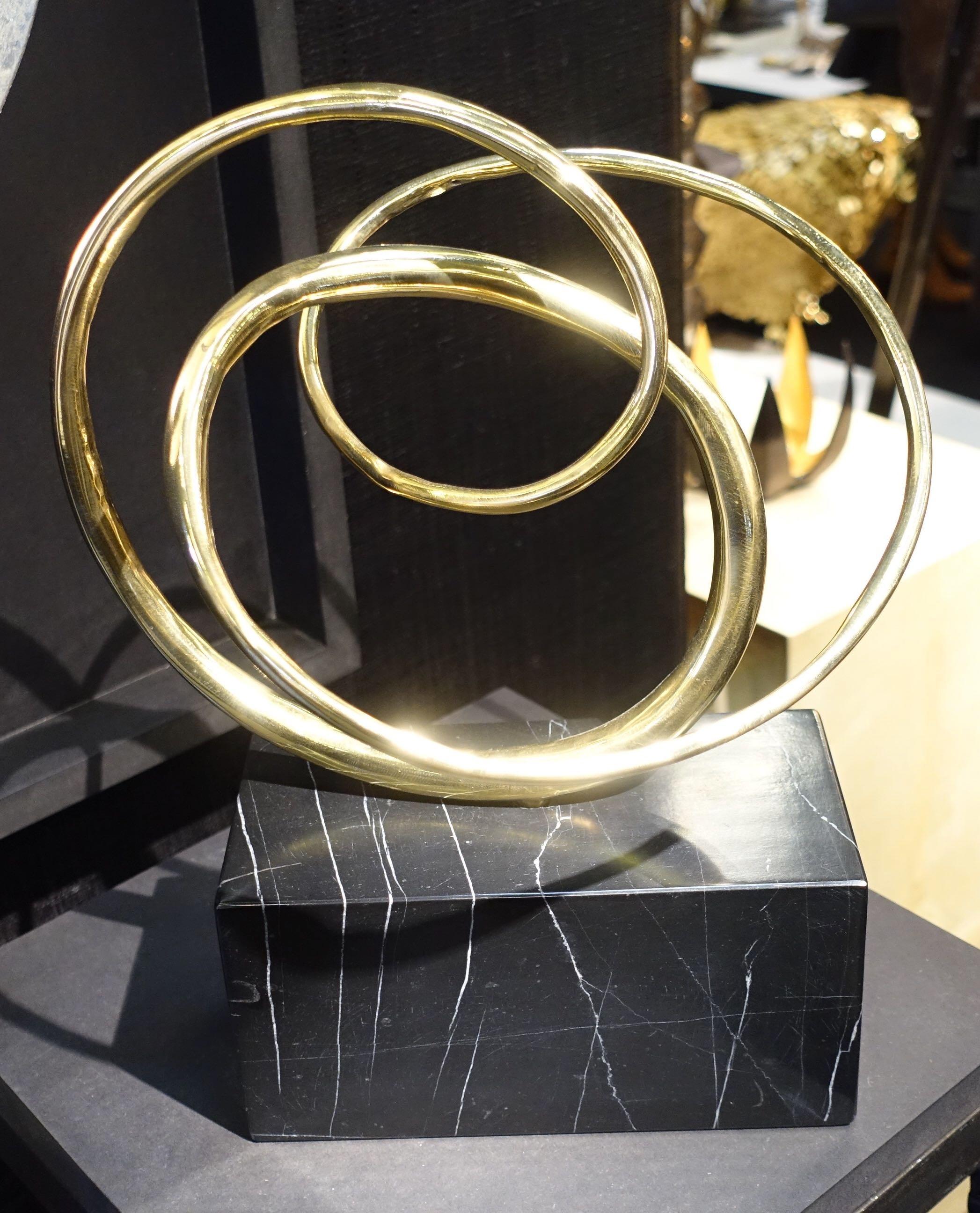 Contemporary German three bronze interlocking rings on black marble stand sculpture.
Moves to show different positions.
Stand measures 8 inches x 4 inches.


 