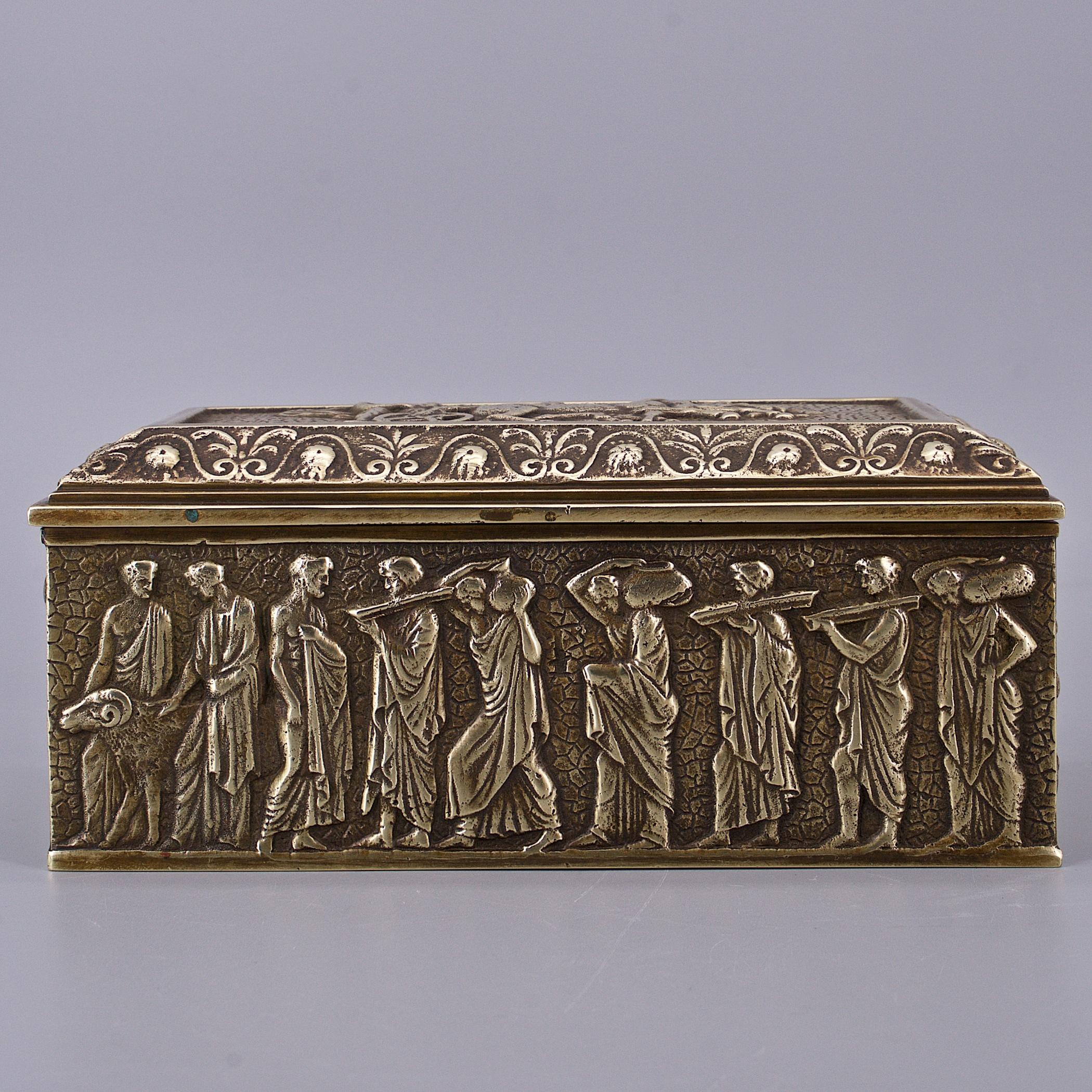 Magnifique boîte en bronze coulé, à charnière et à couvercle, légèrement polie et brillante. Représentation de scènes en relief ou de personnages de l'Antiquité romaine ou grecque. Aucune marque de fabricant n'a été trouvée sur la boîte.