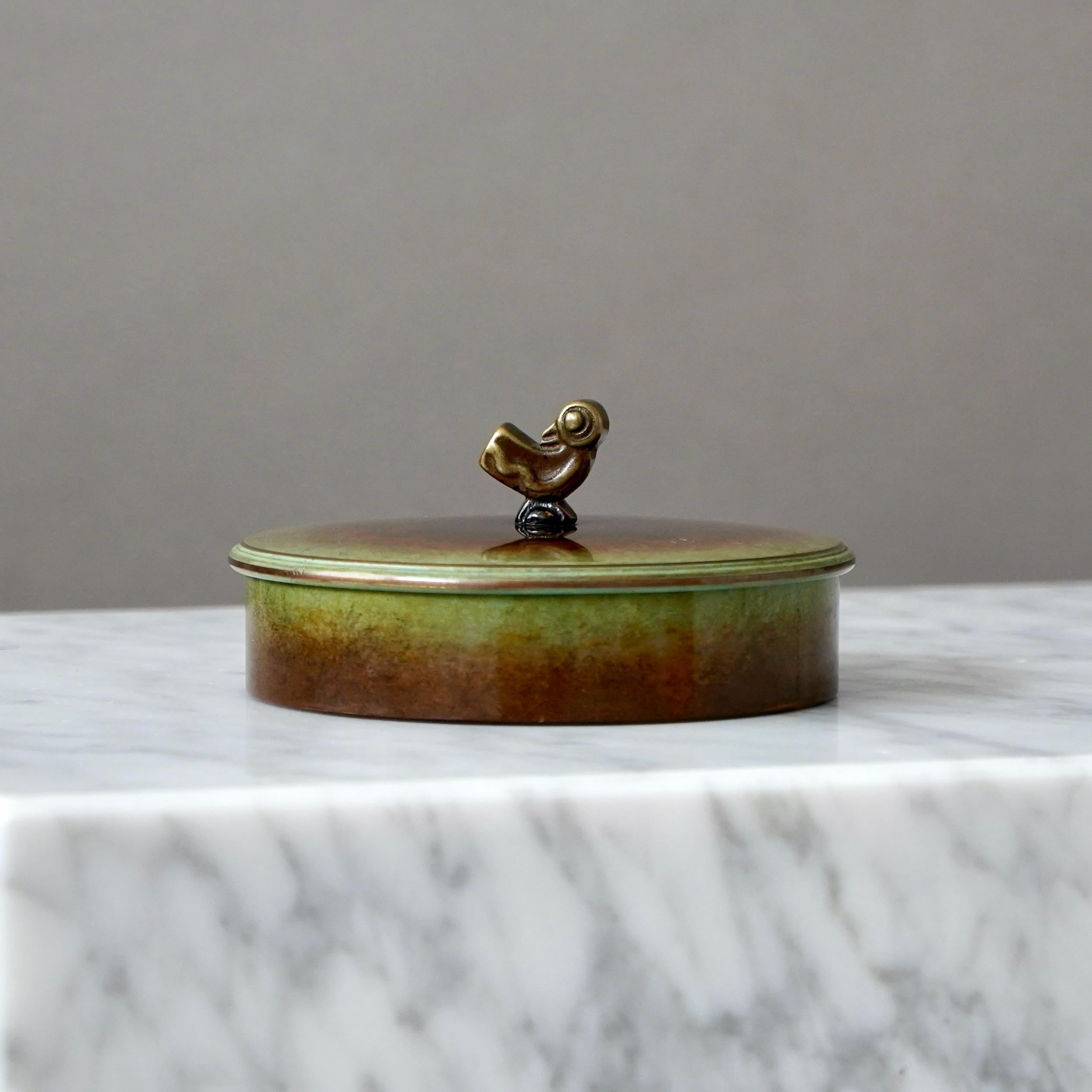 A bronze jewelry box with amazing patina. The lid adorned with a knob in the shape of a bird. Art deco / Swedish Grace. Interior upholstered in green velvet.

Designed by Hans Bergström for Ystad Metall / Brons, Sweden, 1930s.

Great