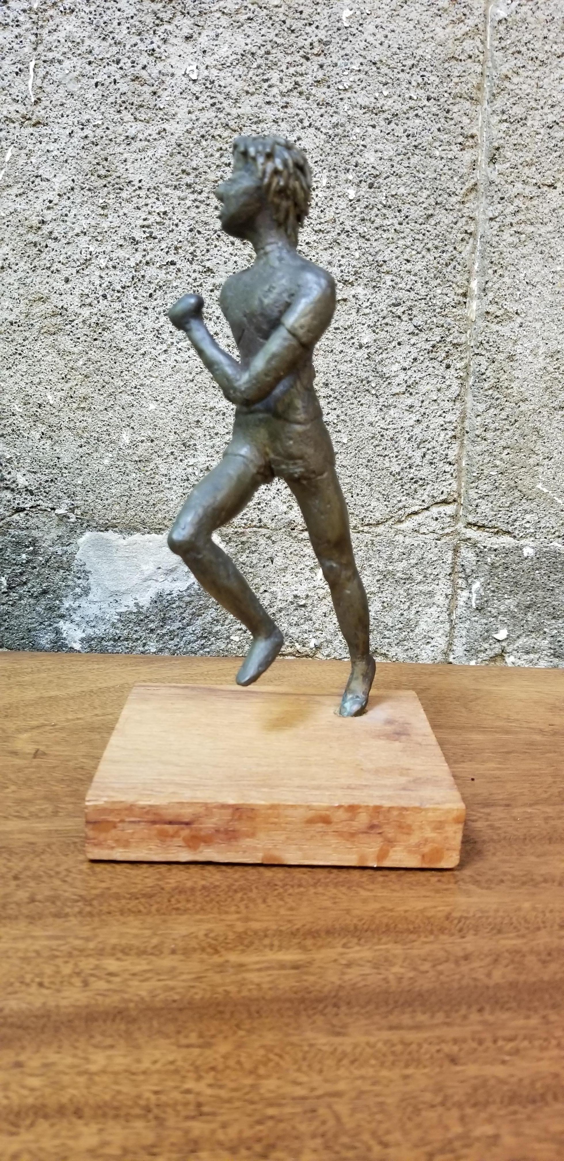 A mid-20th century cast bronze figure of a jogger or runner. Mounted to oak base. Unsigned. Style and era of Curtis Jere.