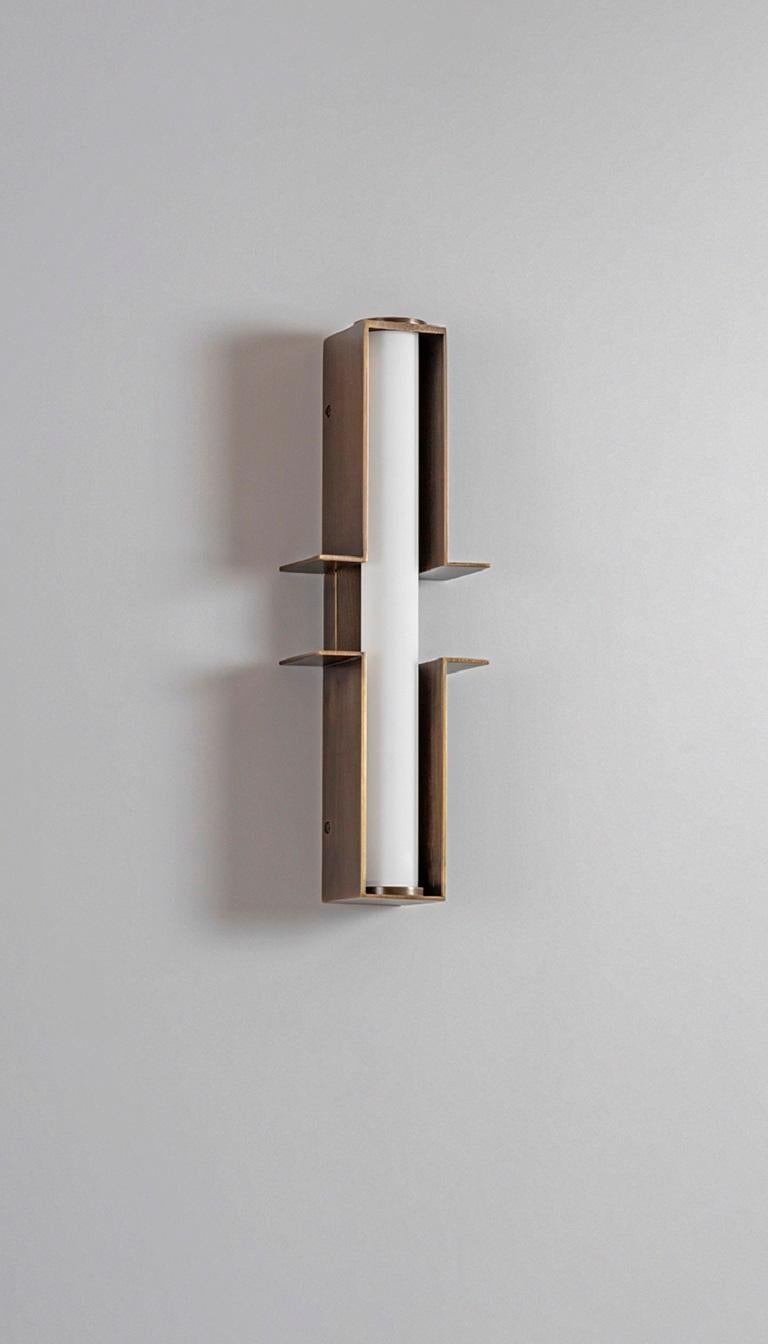 Bronze Junction Wall Light by Square in Circle
Dimensions: W 12,5 x H 38 x D 6 cm
Materials: Dark bronze, white frosted glass tube 

A dark bronze wall light crafted from two parts. Each part extends to the sides, creating a minimalist geometric