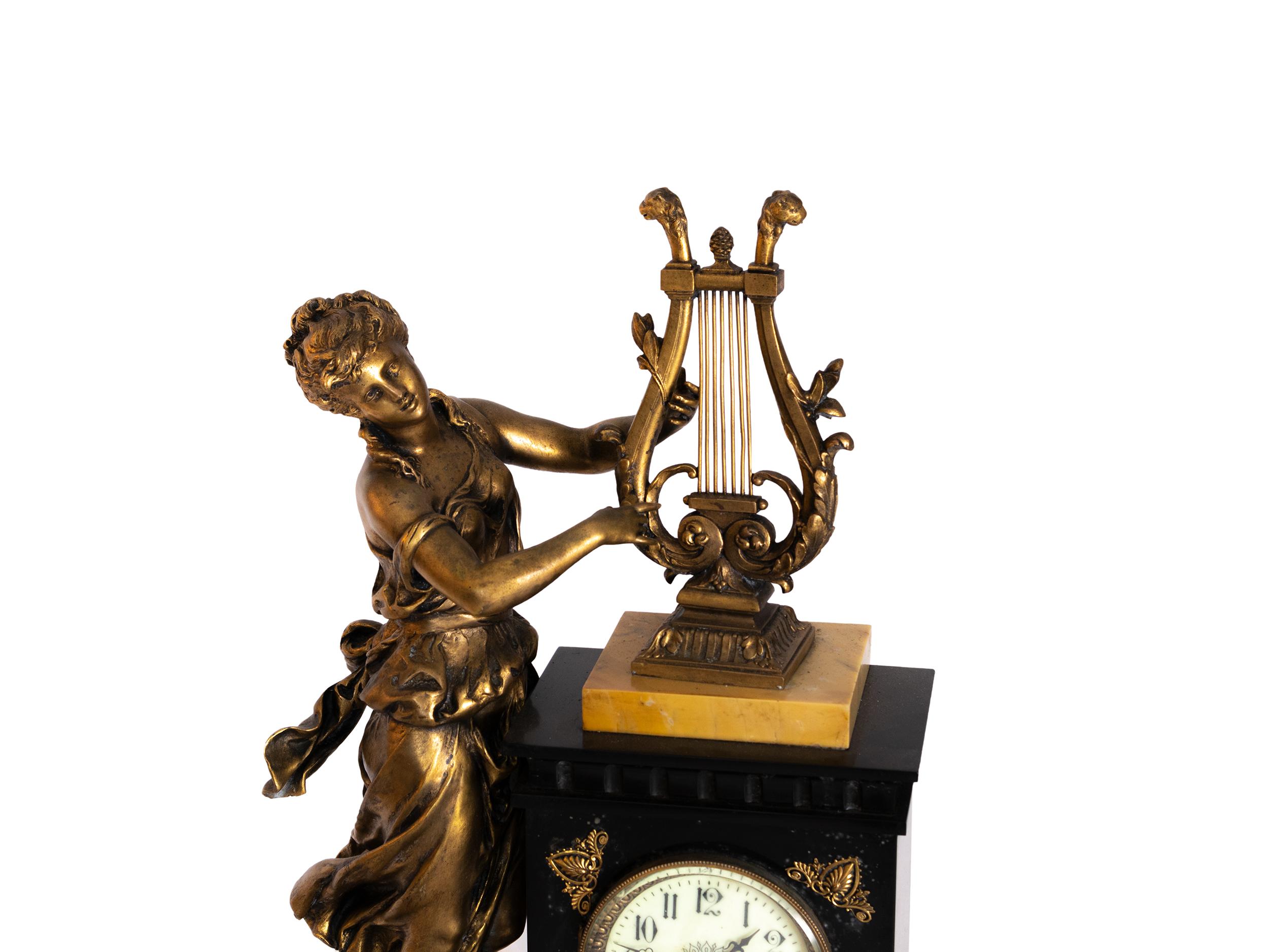 Französische Kaminsimsuhr aus dem frühen 20. Jahrhundert (ca. 1905-1920) mit der Bronzeskulptur einer Harfe spielenden Dame auf einem Sockel aus schwarzem und Siena-Marmor. Diese Uhr erinnert an klassische Themen wie Musik und Anmut und bietet