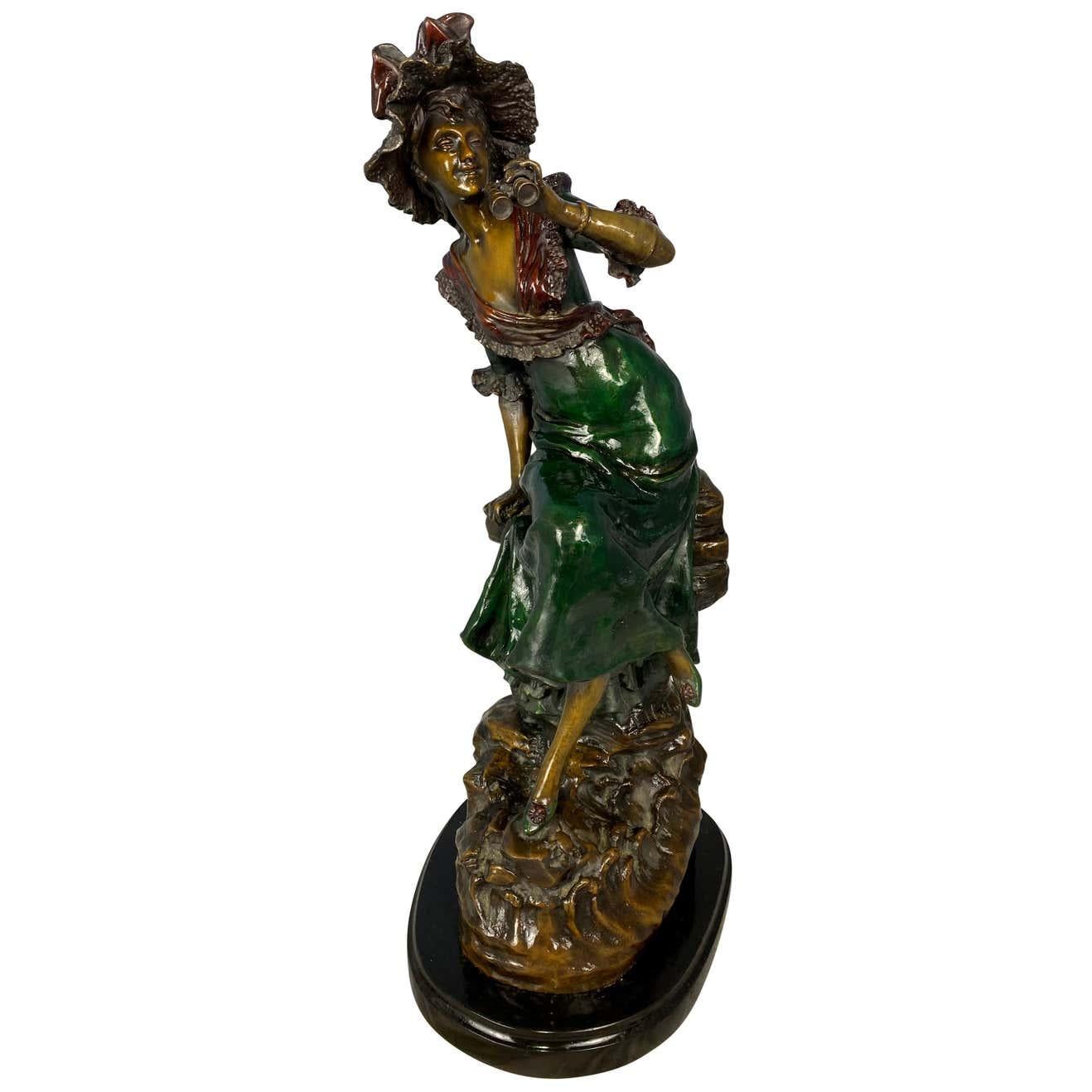 A fine 20th century statue of a two-tone patina bronze woman dressed in Classic Victorian clothing, holding a pair of theatre binoculars. Signed by the French artist Louis Hottot beneath the green dress.