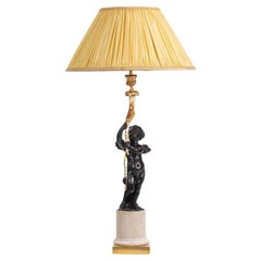 Lampada in bronzo raffigurante un putti, base in marmo. Circa 1880.