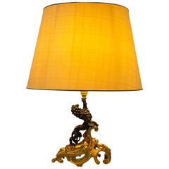 Lampe en bronze avec base dorée en forme de feuille enroulée et lion debout