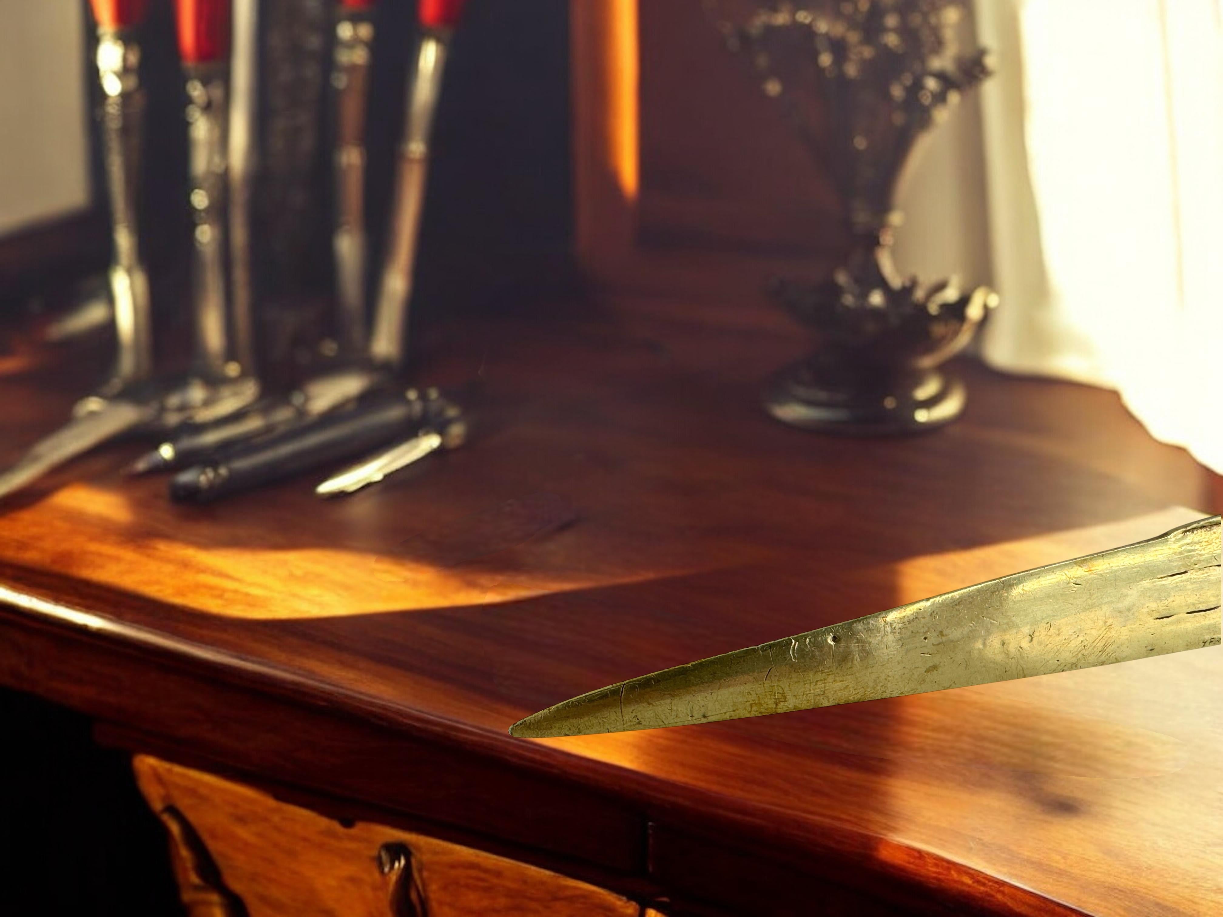 Abrecartas de bronce con la inscripción 